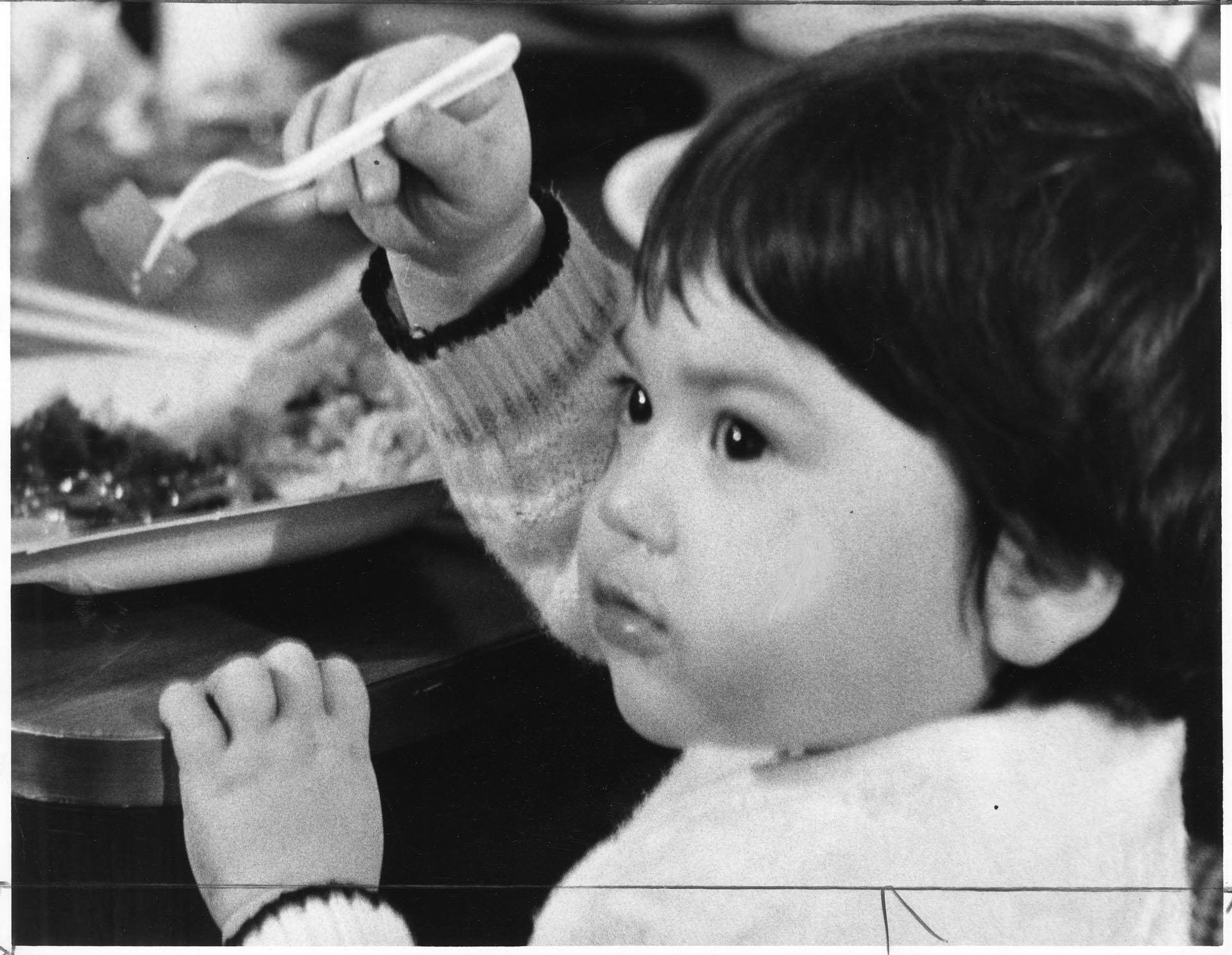 Image of Vietnamese child eating at Camp Murray, Washington, May 21, 1975