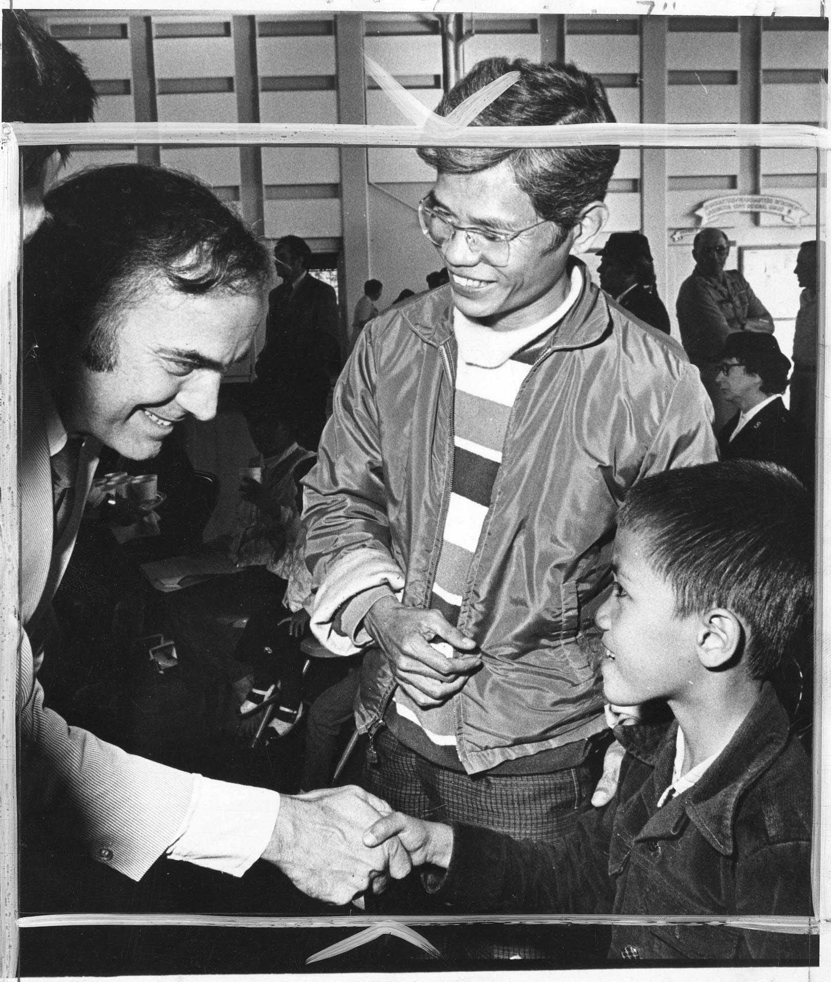 Image of Governor Dan Evans greeting Tony Le and son at Camp Murray, Washington, May 20, 1975