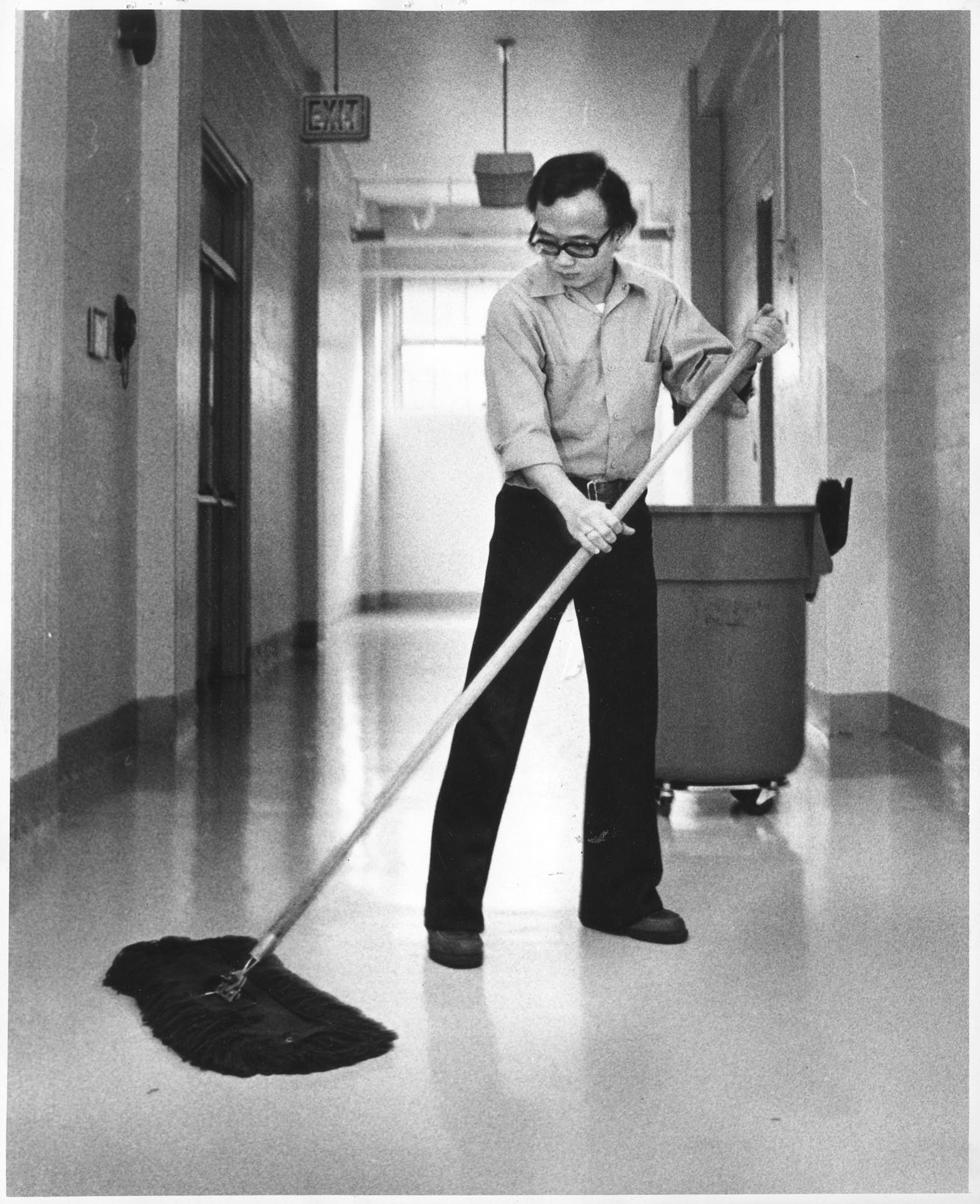 Image of Thien Dac Nguyen mopping floor, Seattle, February 18, 1976
