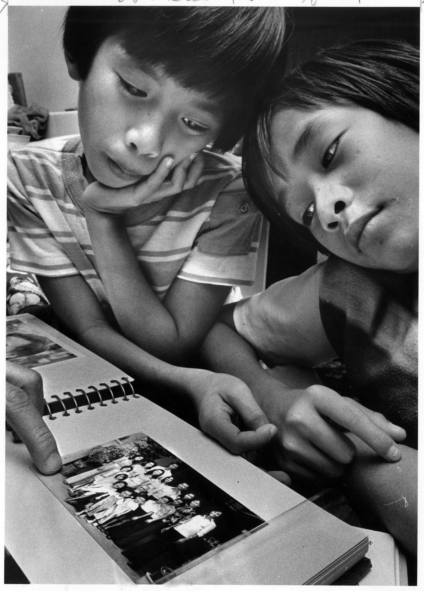 Image of Dai Vu and his brother looking at family photo, Seattle, October 14, 1979