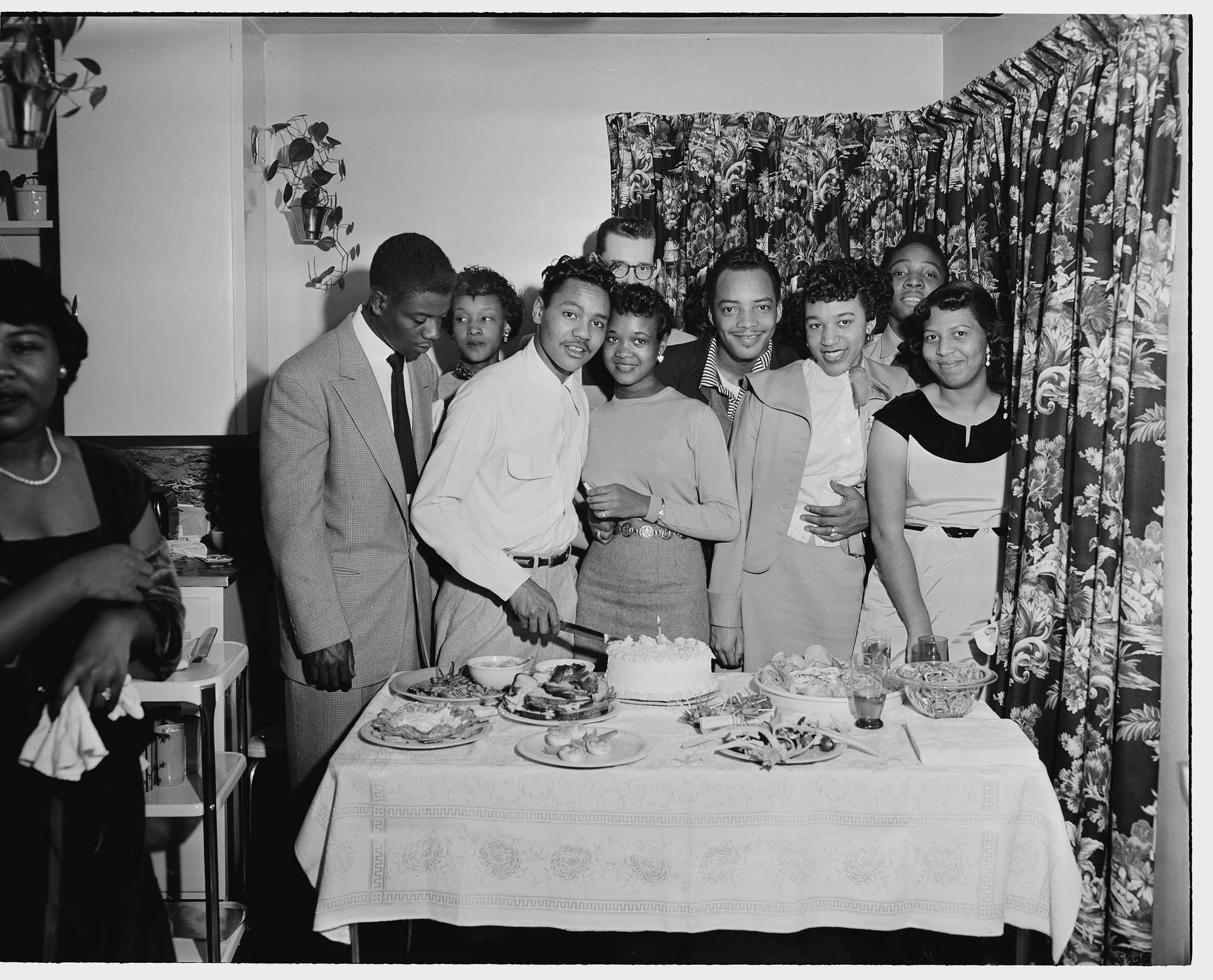 Image of Party-goers posing together by a birthday cake, Seattle, circa 1945