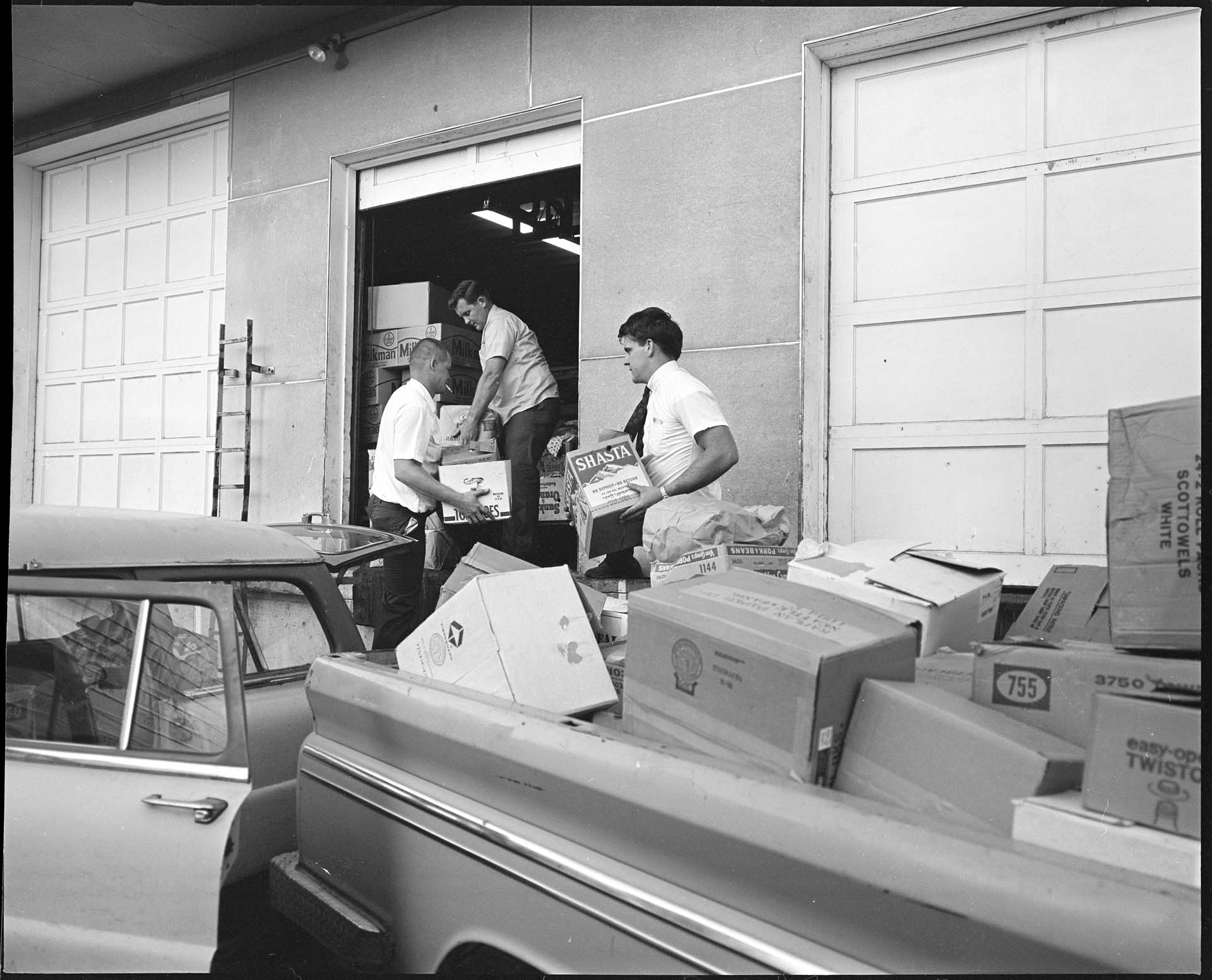 Image of Men delivering boxes of goods for shipment to migrant farm workers, Seattle, August 21, 1967