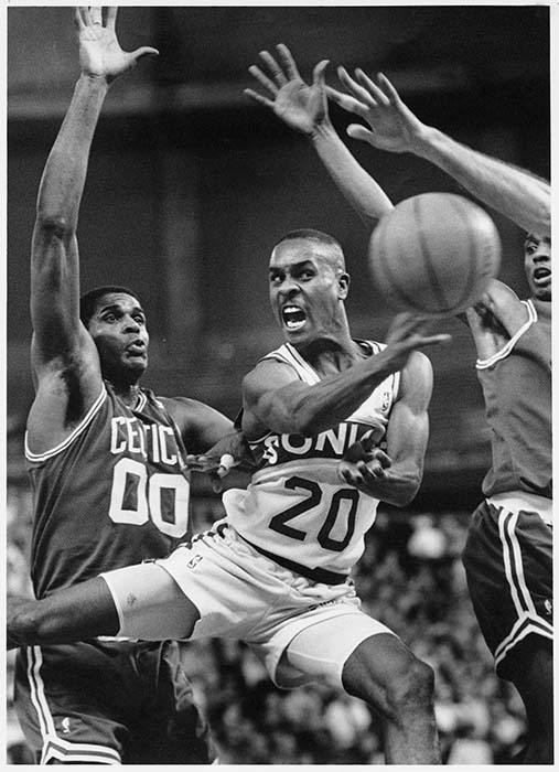 Image of Gary Payton passing basketball in game against Celtics, Seattle, December 29, 1992