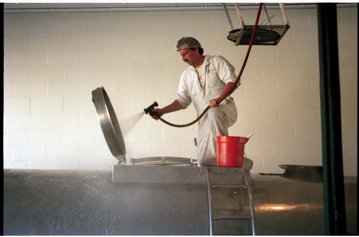 Image of Howard Thompson cleaning out milk truck at Darigold plant, Seattle, September 6, 1993