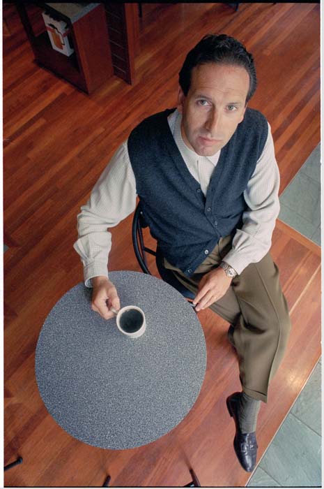 Image of Howard Schultz sitting at table with cup of coffee, Seattle, October 7, 1993