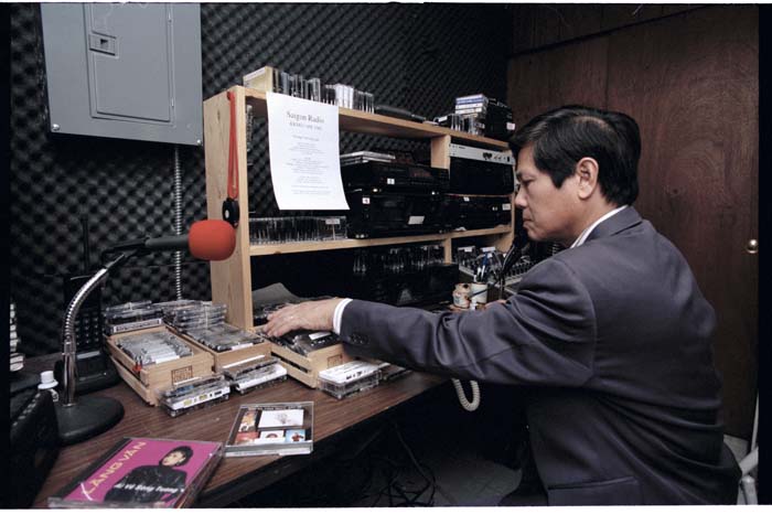Image of Quốc Nam choosing music for Saigon Radio, Seattle, August 21, 1996