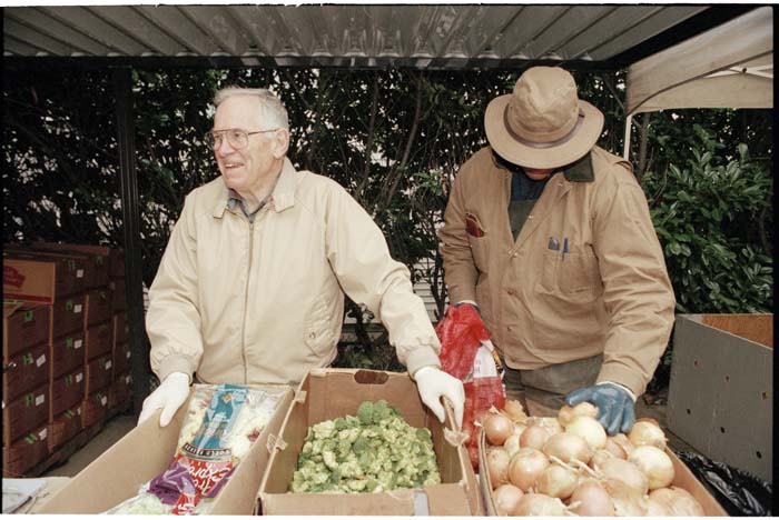 Image of Volunteer Henry Seaman distributing food at Northwest Harvest food bank, Seattle, December 1996