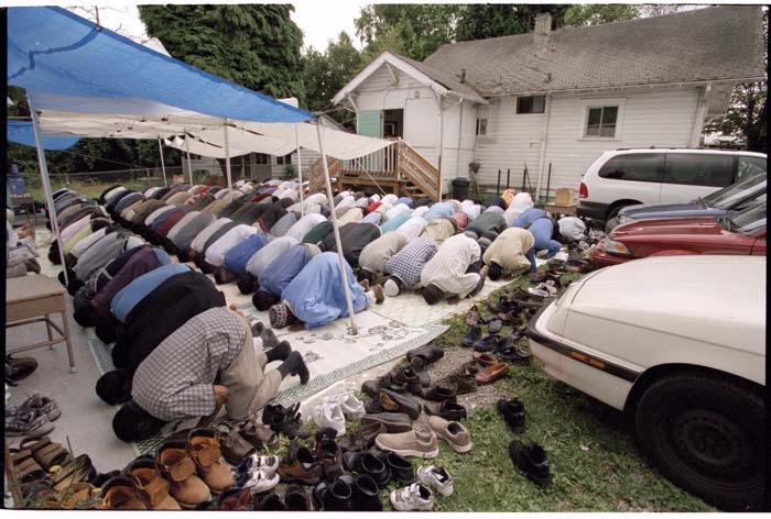 Image of Men bowing during worship outside the Masjid Al-Salaam, SeaTac, August 3, 2001