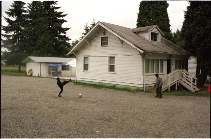 Image of Boy kicking soccer ball outside the Masjid Al-Salaam mosque building, SeaTac, August 3, 2001
