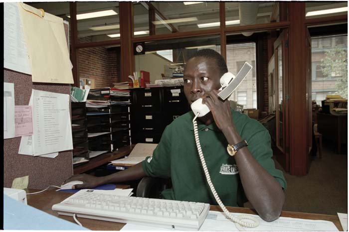 Image of William Deng working at the International Rescue Committee office, Seattle, August 2001