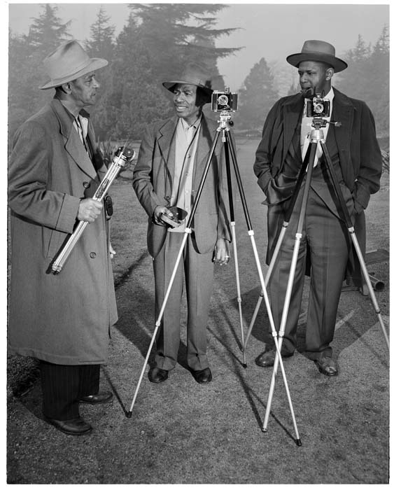 Image of Three photographers with cameras outdoors, circa 1950