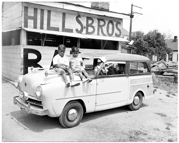Image of Two children sitting on car in front of Hills Bros. BBQ, Seattle, circa 1953