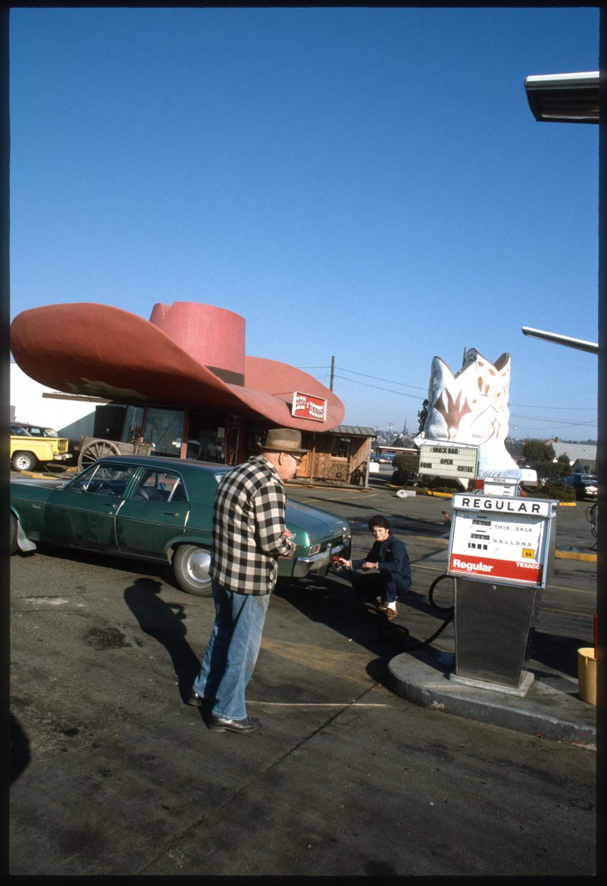 Image of Customer getting gas at the Hat 'n' Boots Texaco station, Seattle, 1985