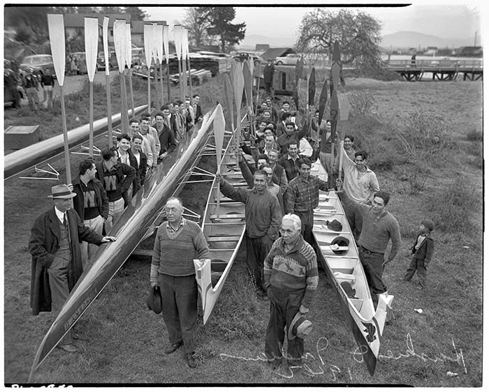 Image of Husky crew team with shells and Indigenous rowers with canoes, La Connor, November 29, 1941