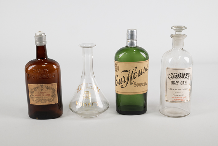Image of Set of four liquor bottles from the Our House restaurant and hotel in Seattle, ca. 1898-1958