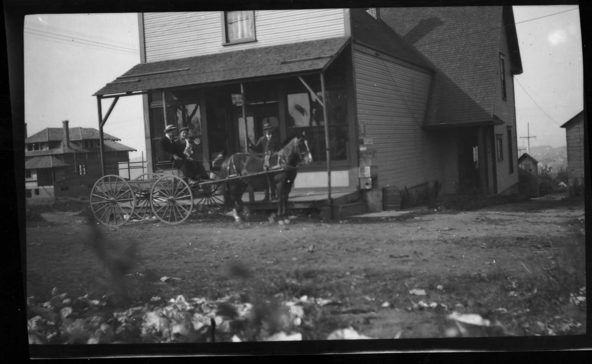 Image of Horse-drawn wagon in front of store, probably in Seattle, circa 1915