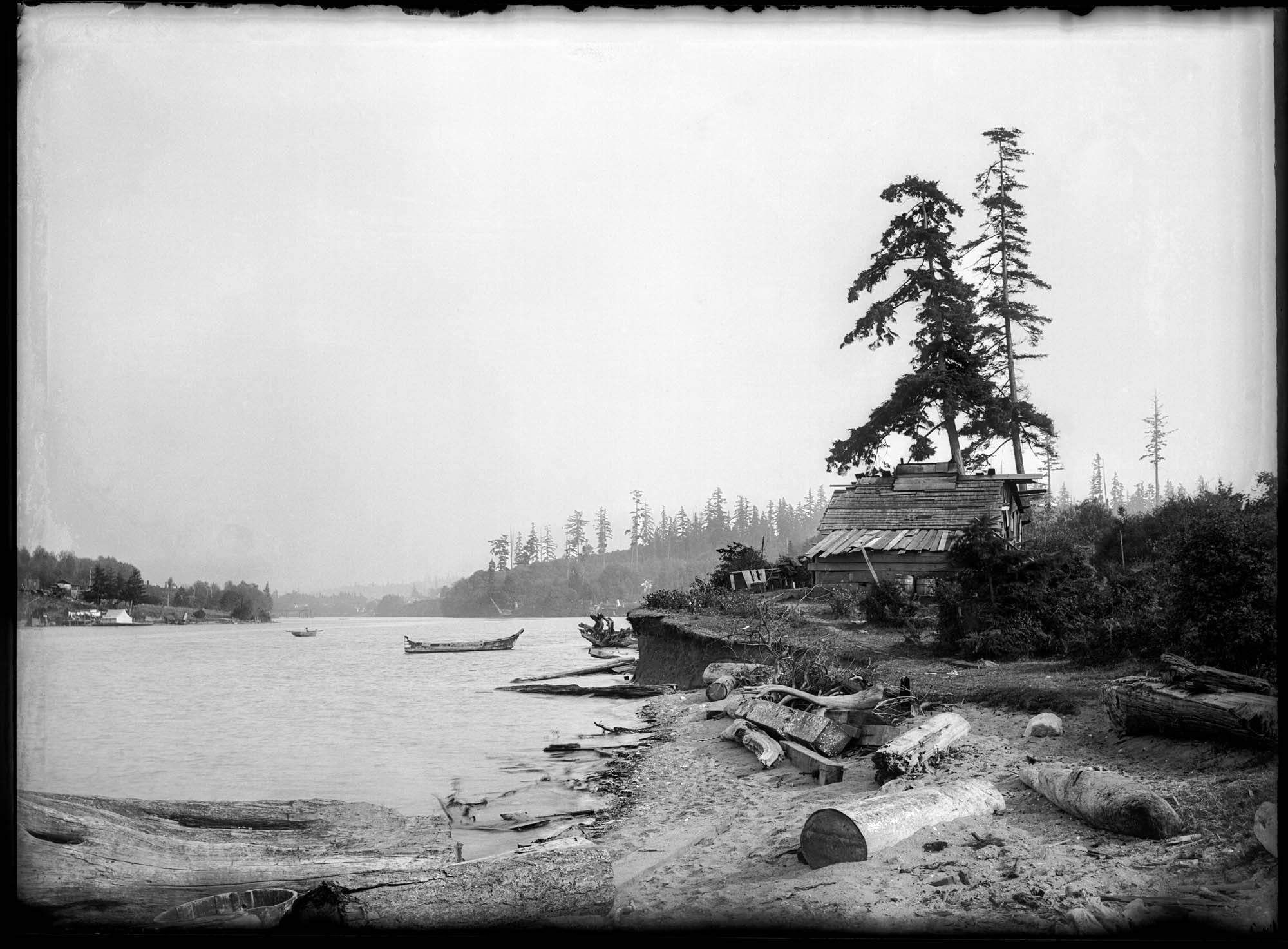 Image of Hwehlchtid's house at Shilshole with canoe anchored offshore, circa 1905