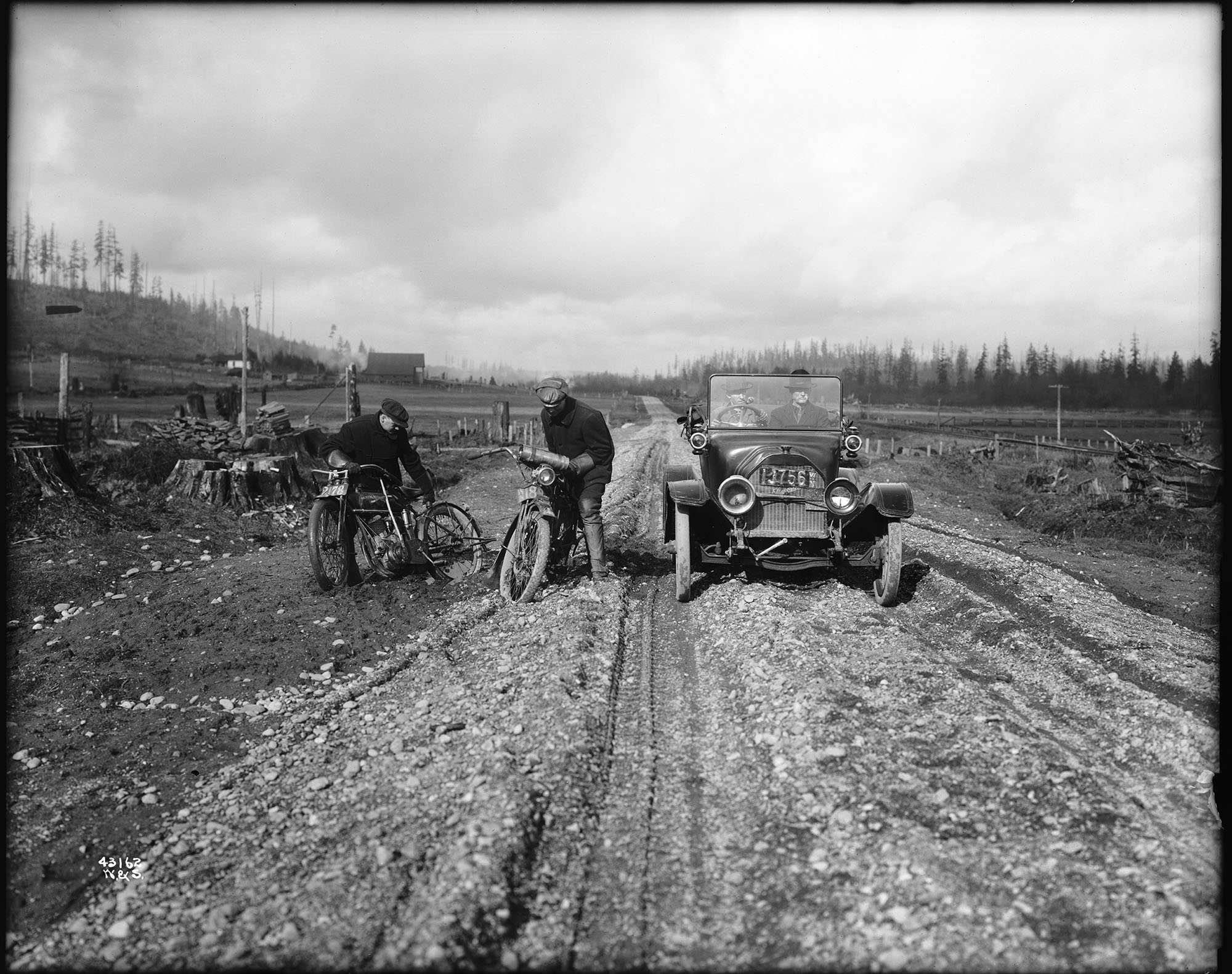 Image of Studebaker roadster and two motorcycles on rutted road, Bothell, circa 1914