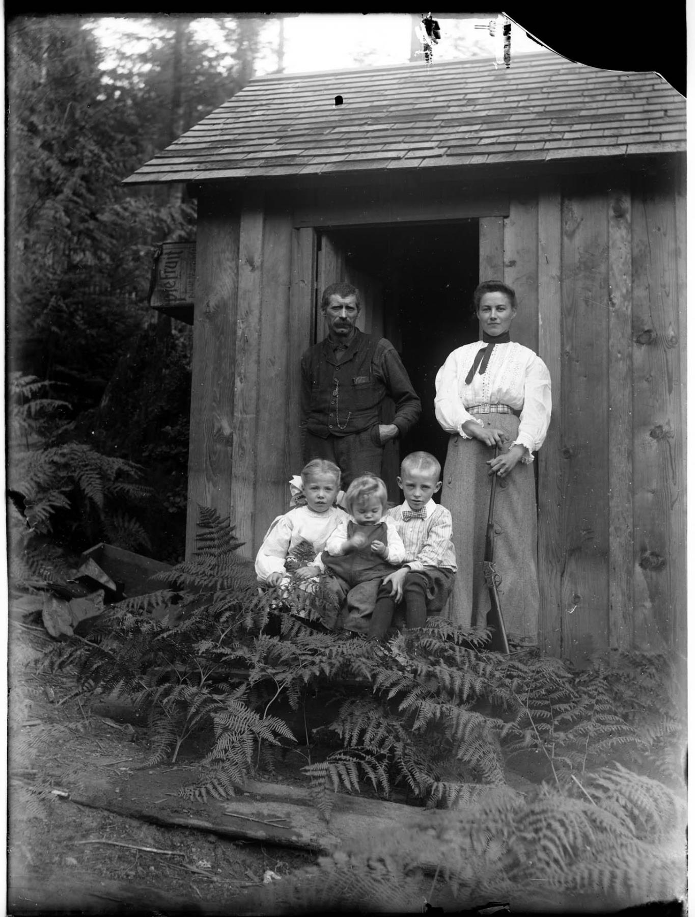 Image of Eli Stanford and family in front of cabin, circa 1900