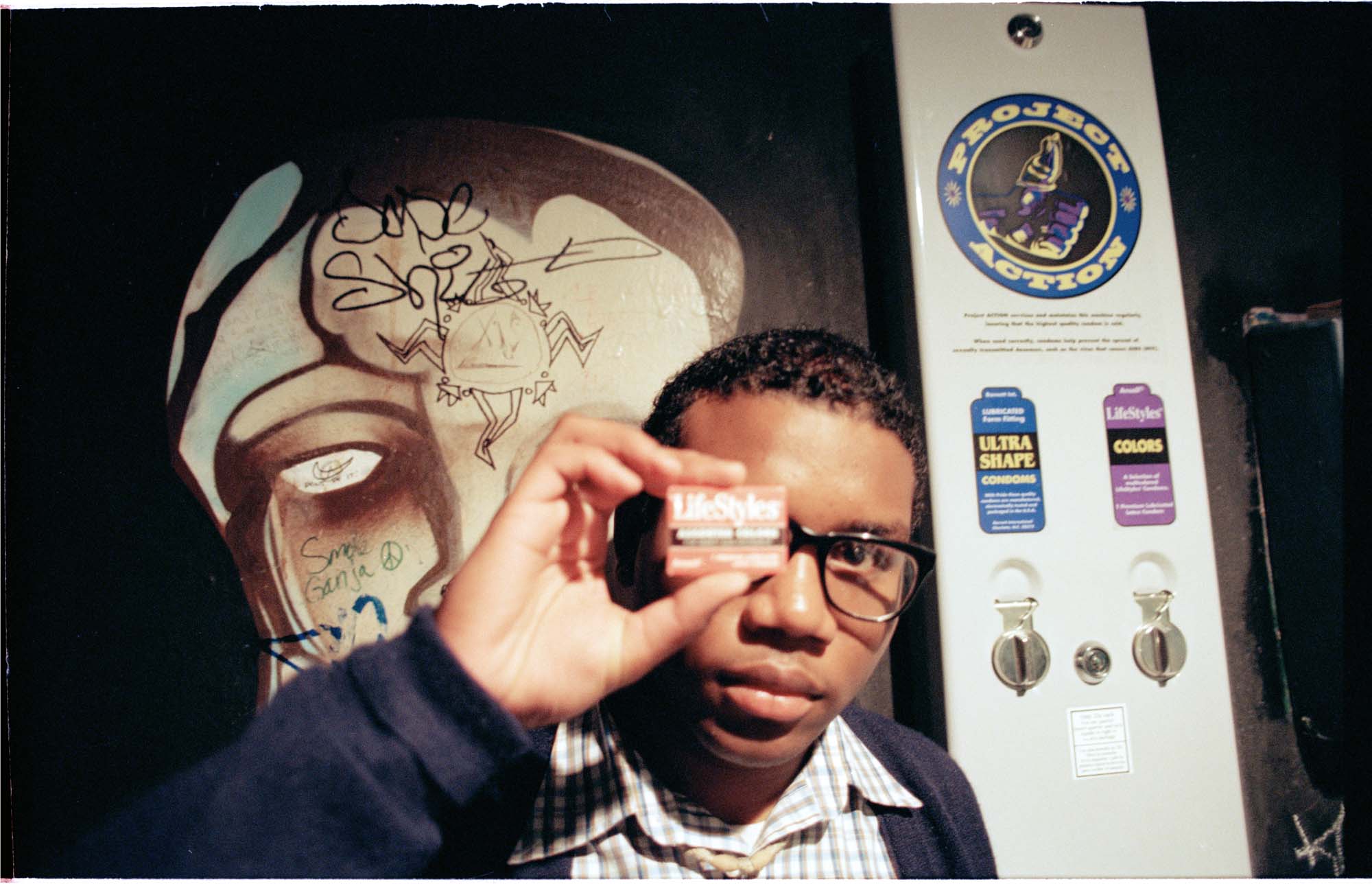 Image of Project ACTION member near condom dispenser, Seattle, April 3, 1997