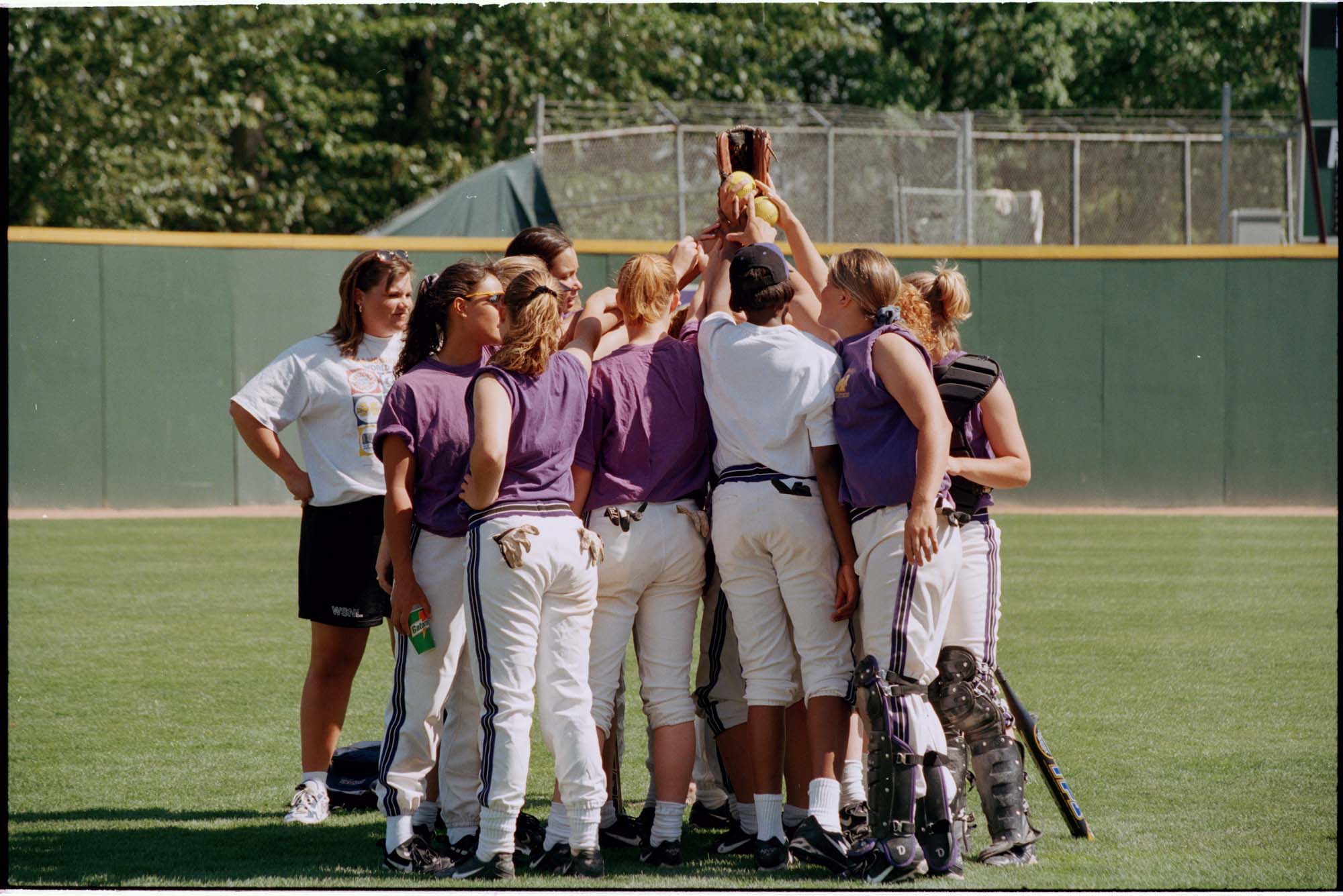 Image of University of Washington women's softball team in huddle, Seattle, May 13, 1997