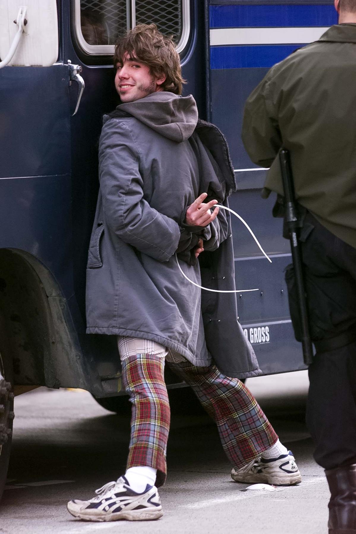 Image of WTO protester leaning on police van with hands tied, Seattle, November 30, 1999