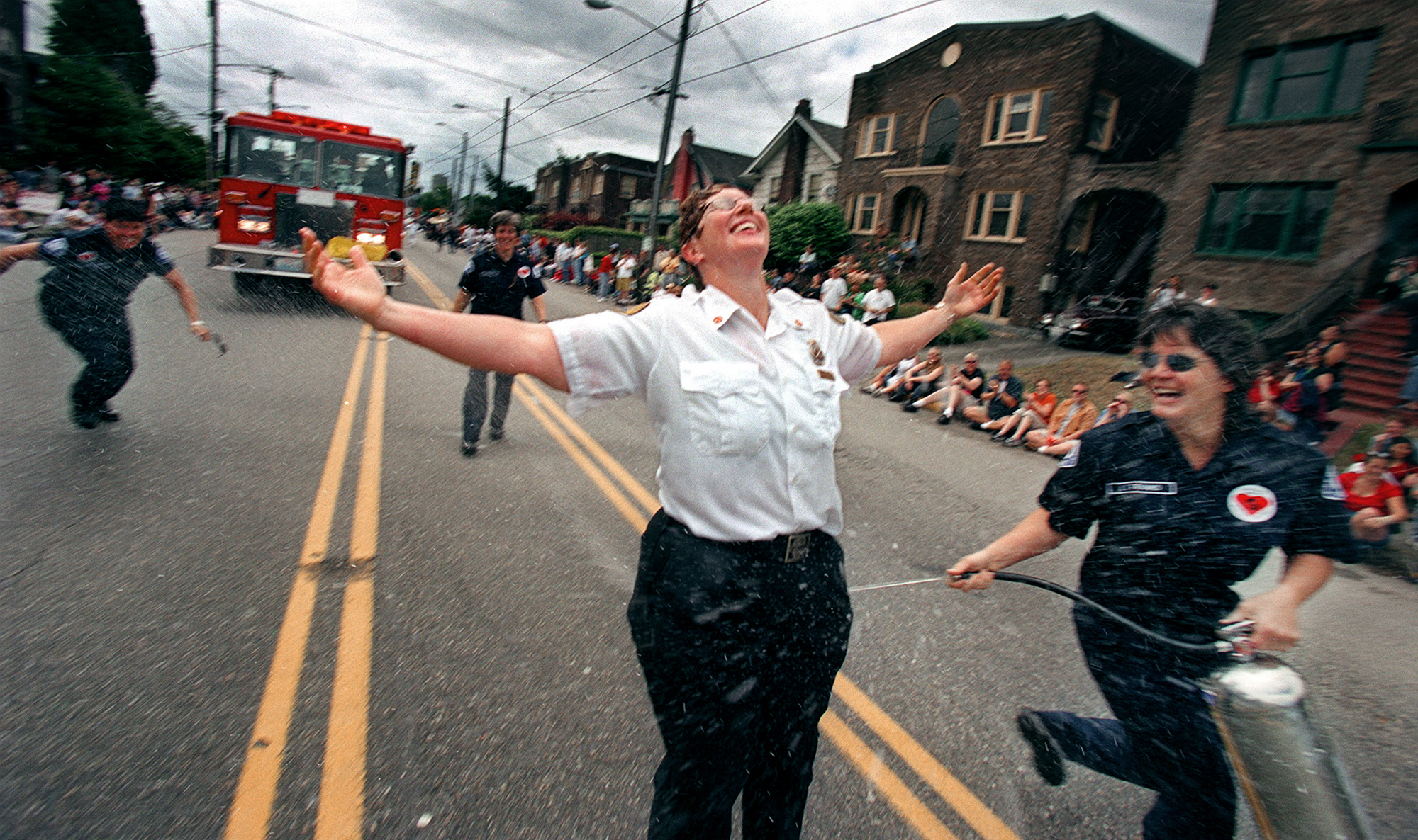 Image of Lt. Tracy Franks spraying Chief Molly Douce with fire extinquisher during Pride Parade, Seattle, June 30, 2002