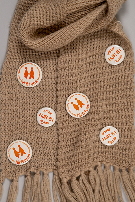 Image of Knit scarf with a collection of HJR 61 buttons attached, ca. 1972