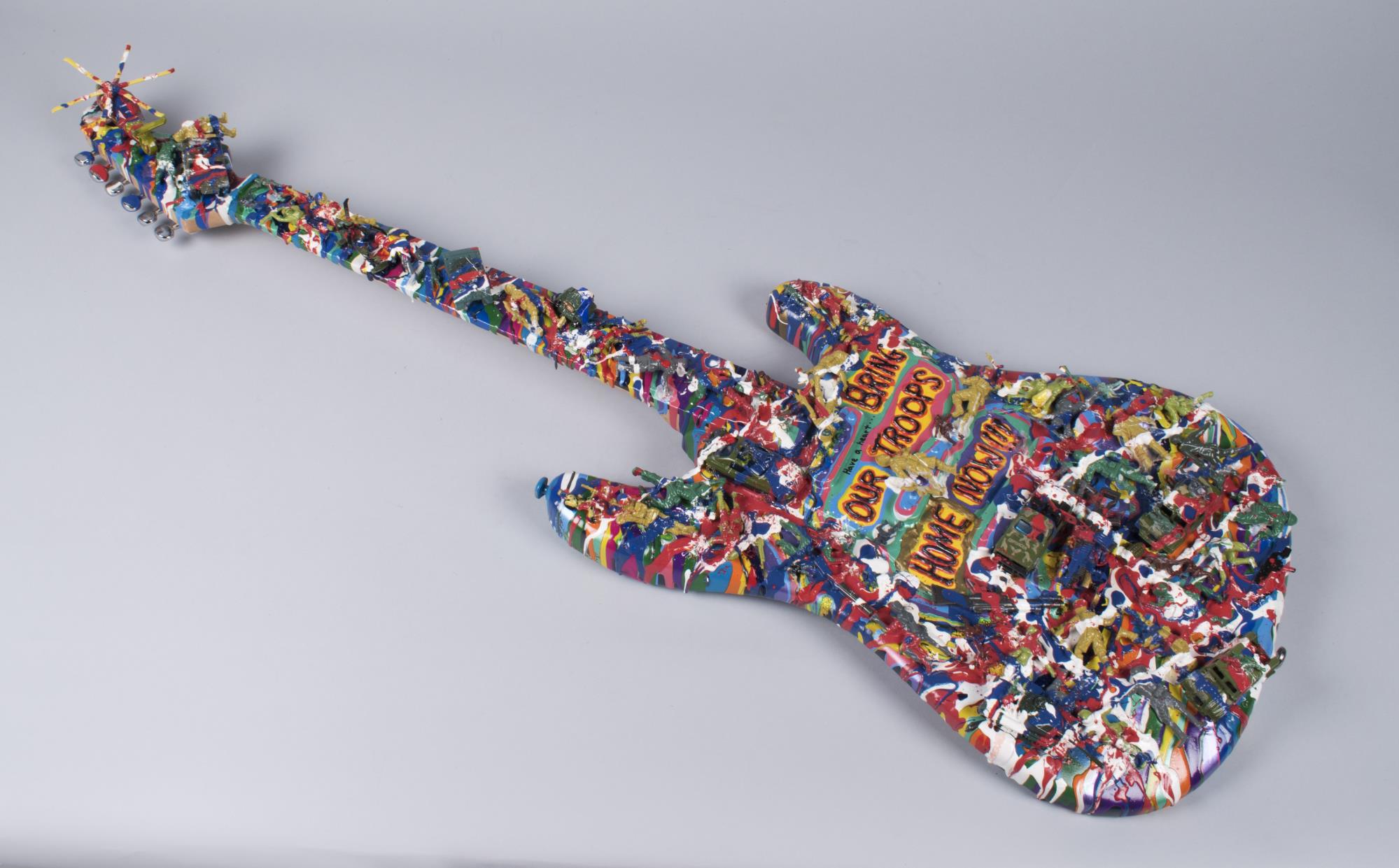 Image of War protest art assemblage, guitar covered with paint and army toys, 2004