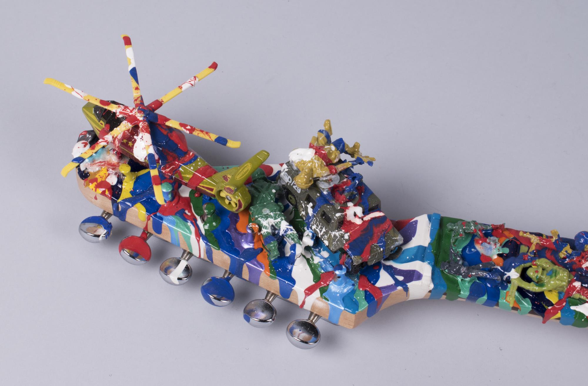 Image of War protest art assemblage, guitar covered with paint and army toys, 2004