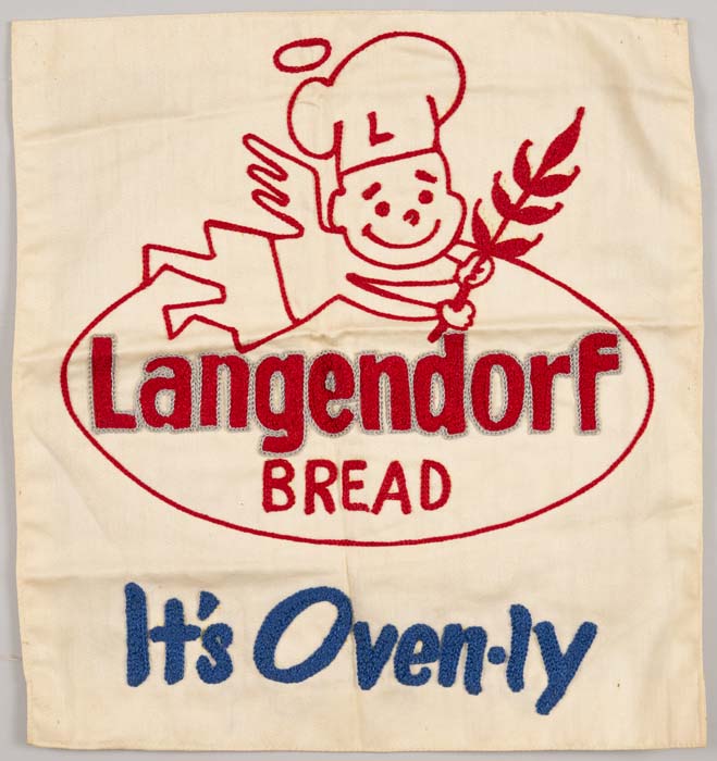 Image of Patch of embroidered cloth, probably for an apron, with the Langendorf Bread company logo and the motto, 