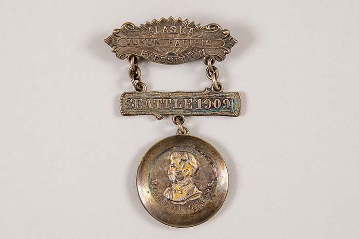 Image of Alaska-Yukon-Pacific Exposition (AYPE) souvenir pin featuring William H. Seward, Seattle, 1909