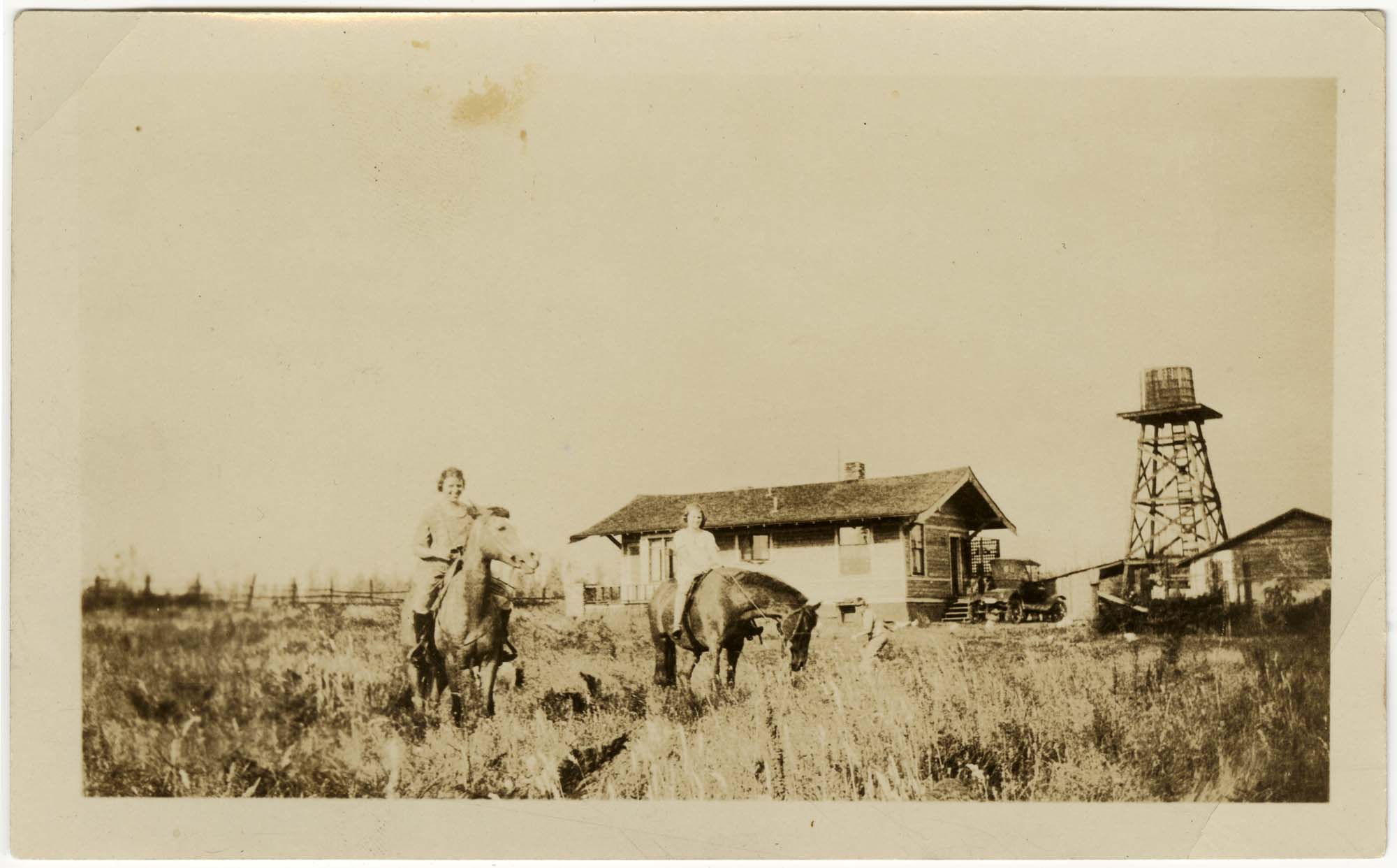 Image of Two young women on horses, with farmhouse in background, Seattle, circa 1930