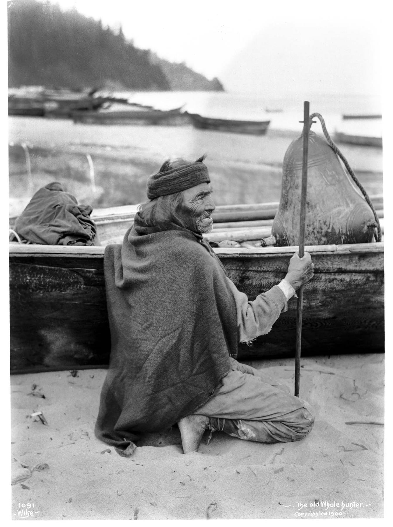 Image of Makah whale hunter with canoe and floats at Neah Bay, 1900