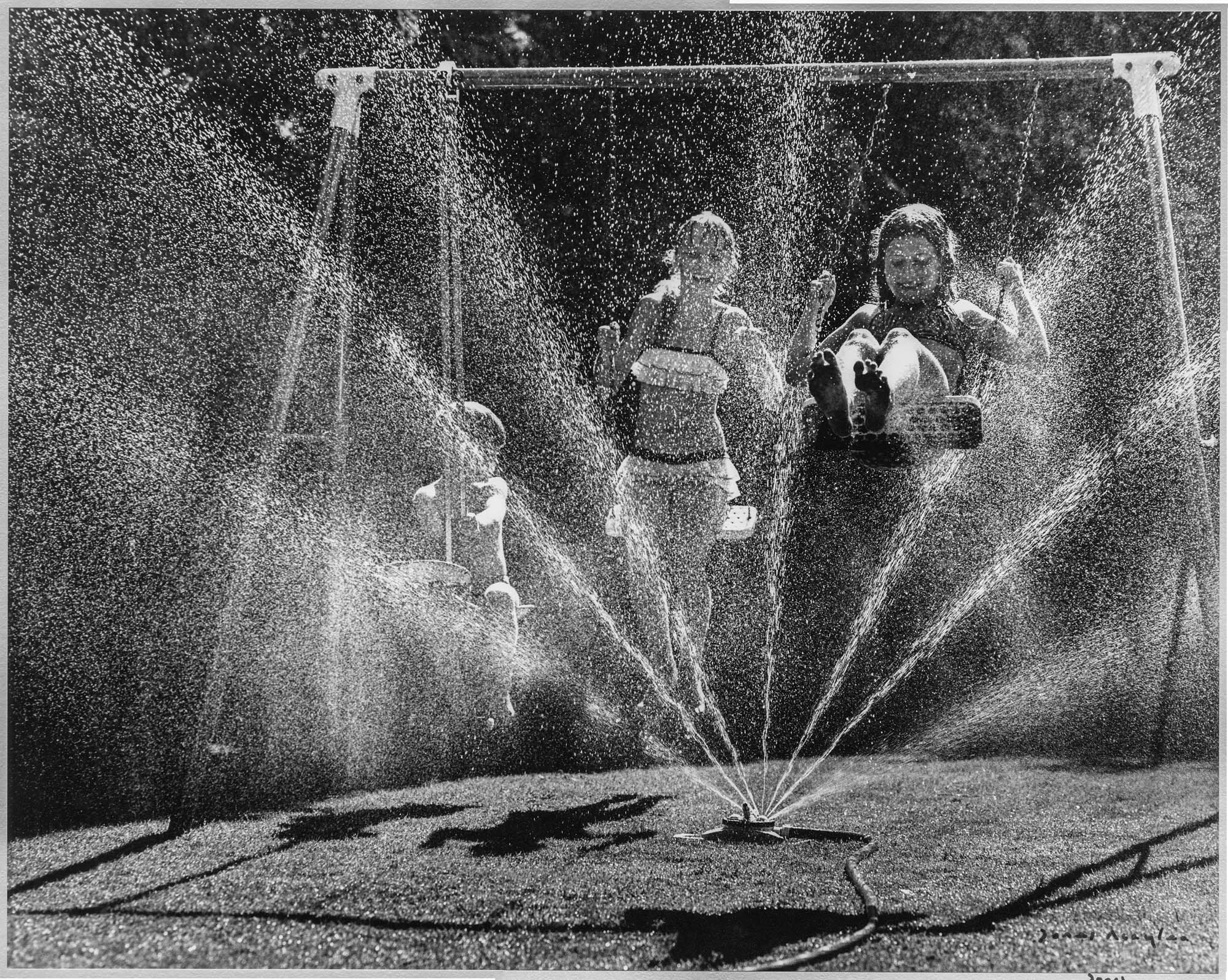 Image of Children swinging near sprinkler at View Ridge Playfield, Seattle, 1964