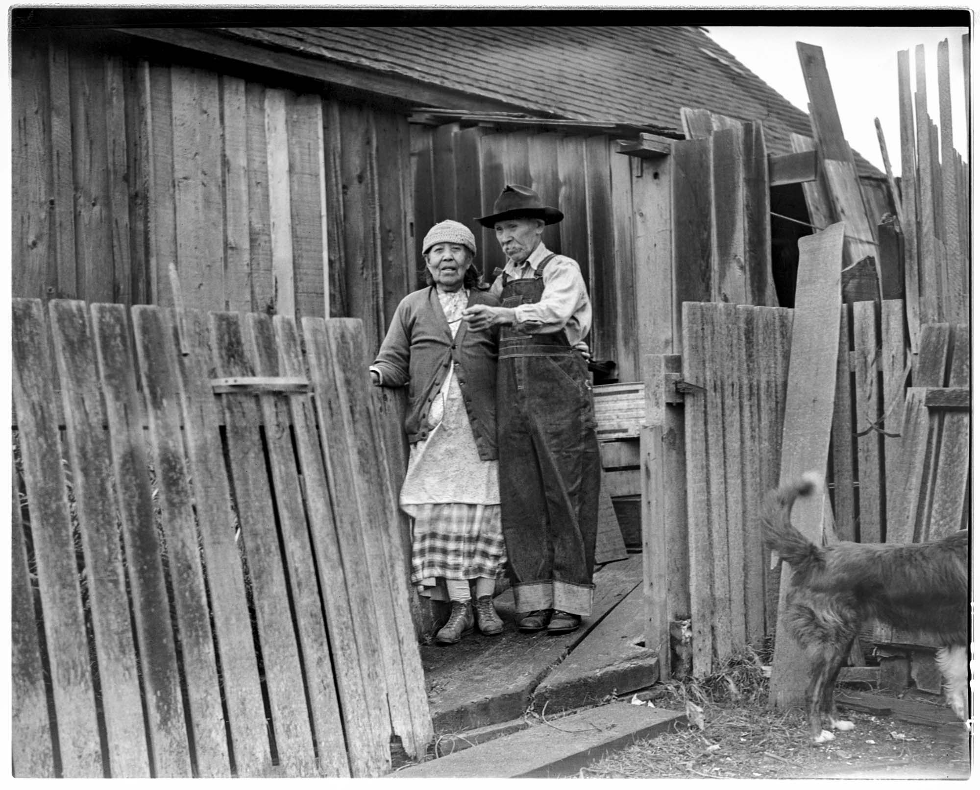 Image of George and Mary Adams standing outside their home, Port Gamble Reservation, February 1939
