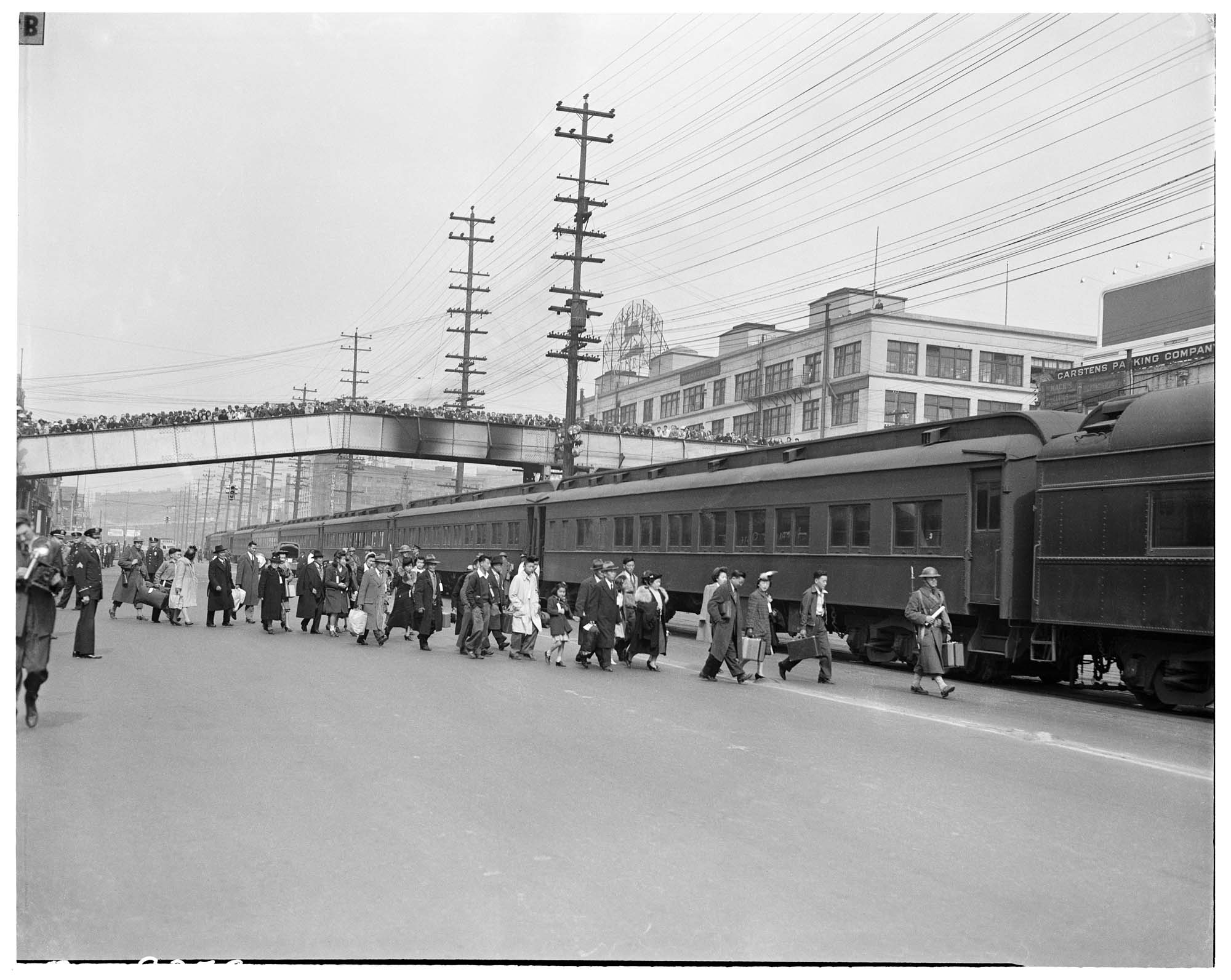Image of Bainbridge Island incarcerees walking to train, March 30, 1942
