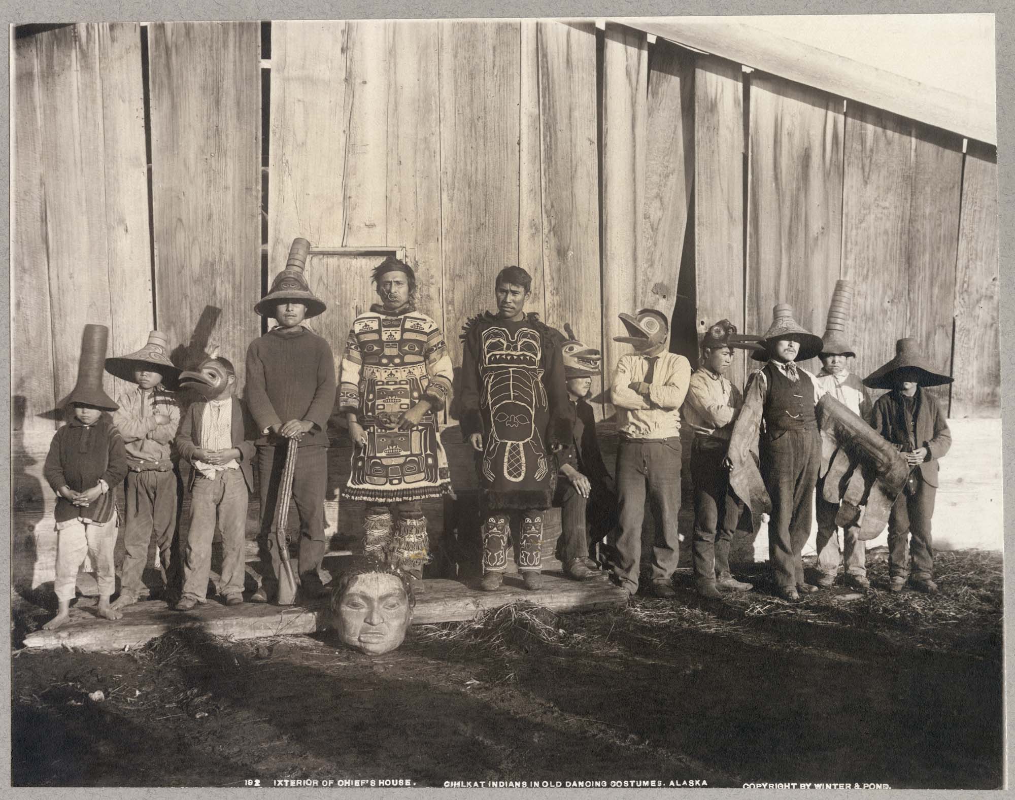 Image of Group of Chilkat people in traditional dance costumes, Klukwan, Alaska, circa 1895