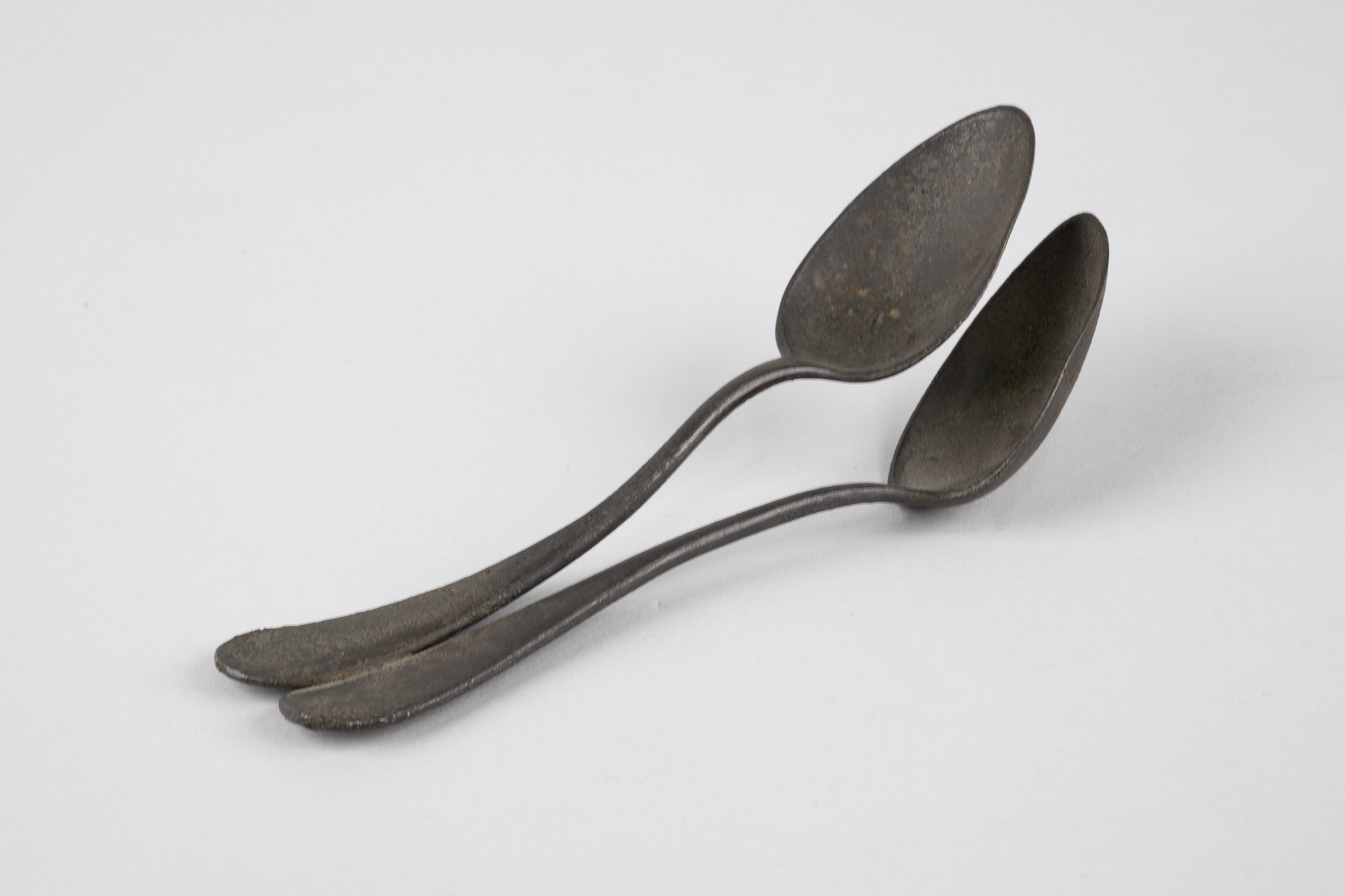 Image of Two silver spoons melted together from the Seattle Fire of 1889
