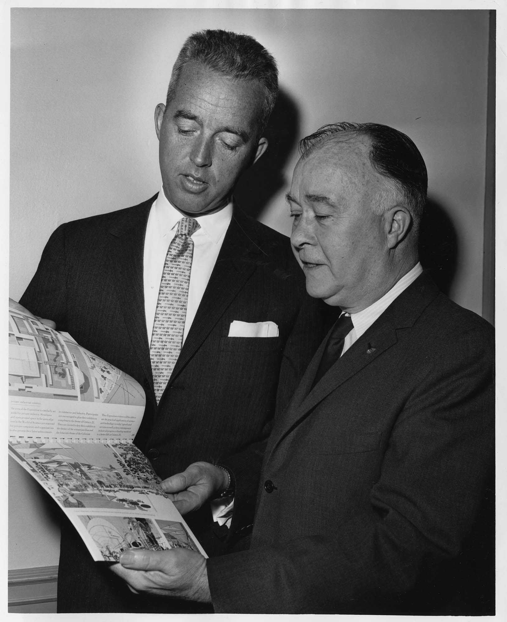 Image of Otto Brandt and Lee Moran looking at Century 21 brochure, Seattle World's Fair, circa 1961