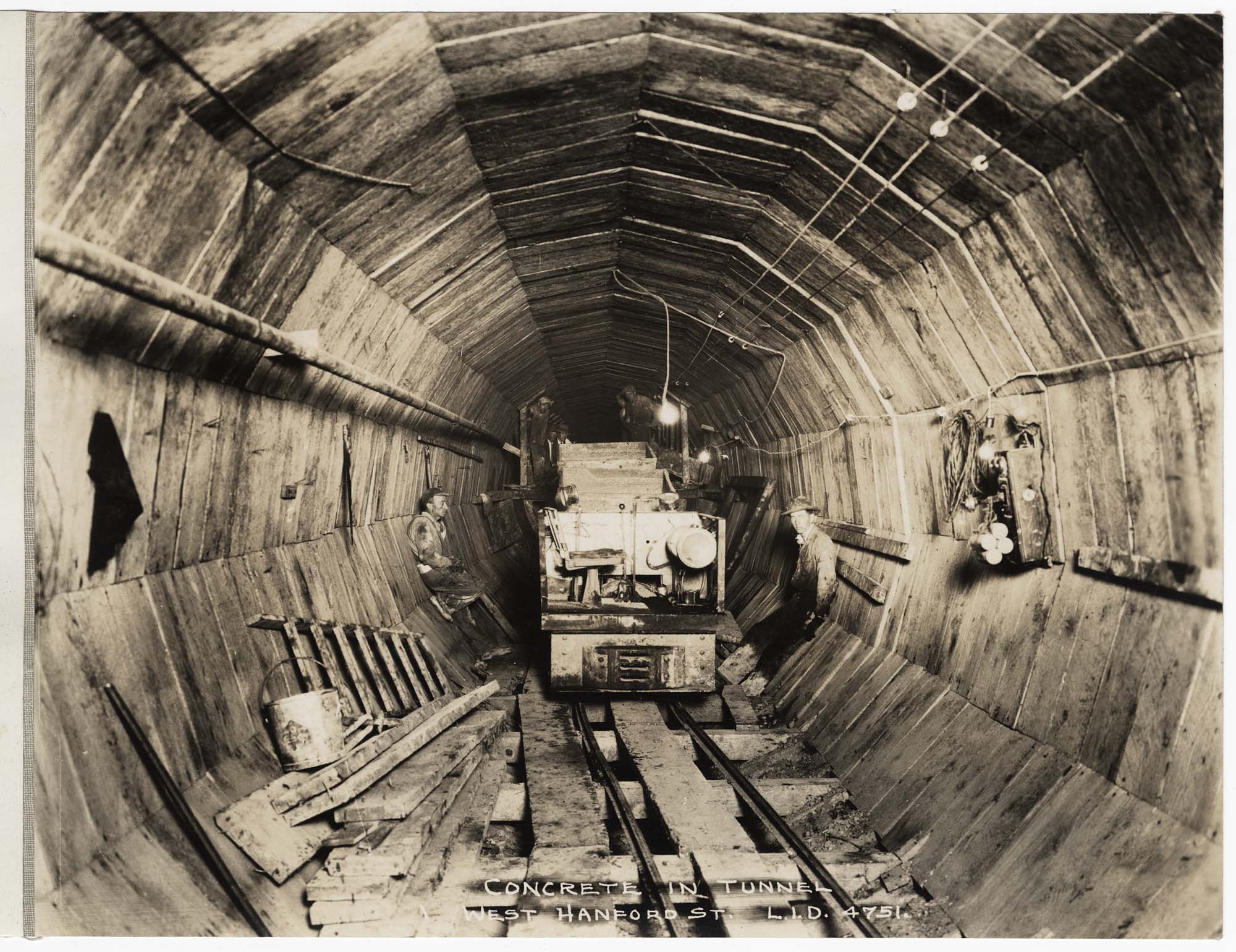 Image of Workers and car loaded with concrete in tunnel, circa 1929