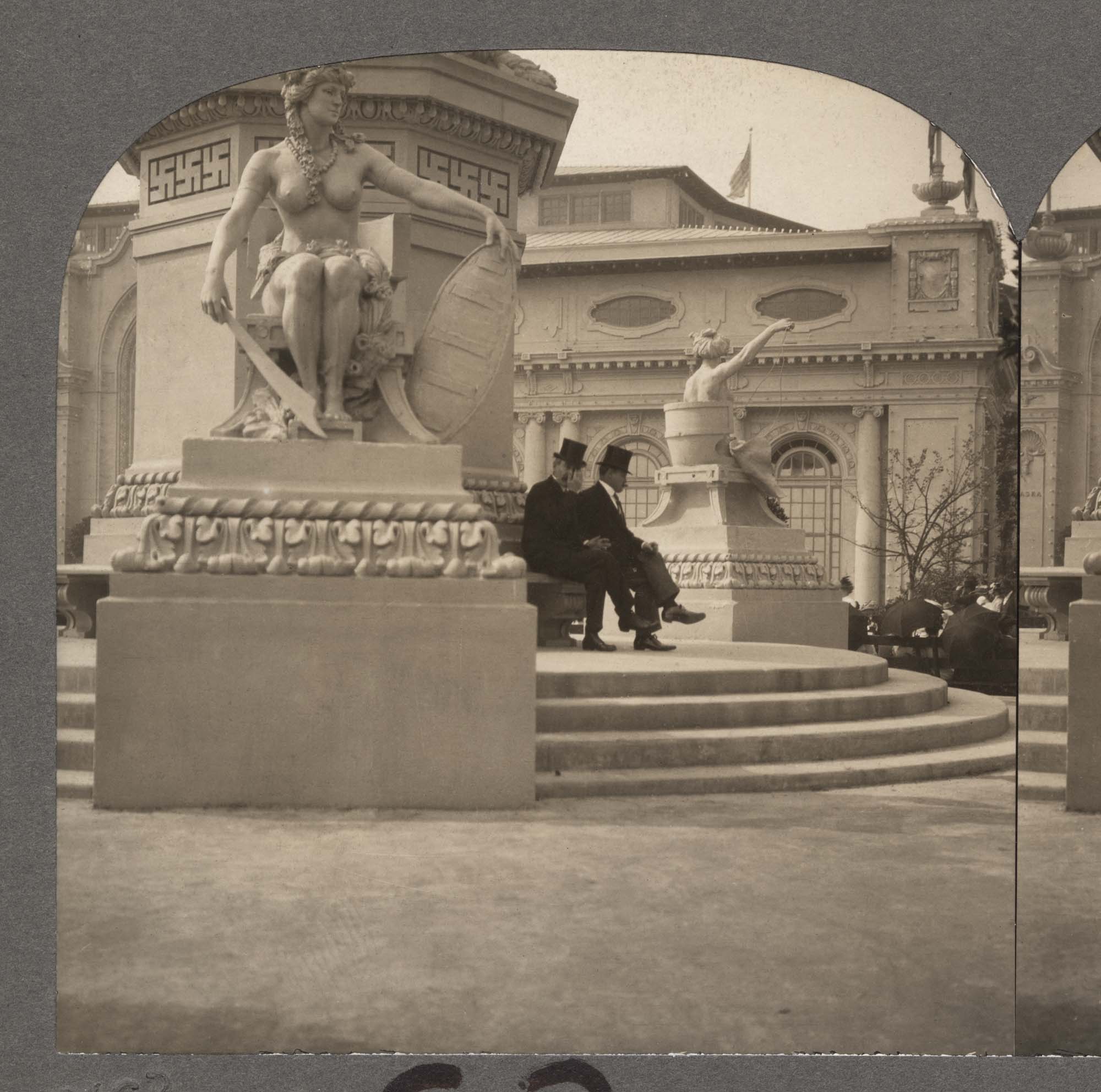 Image of Two men seated at base of Alaska Monument, Alaska-Yukon-Pacific Exposition, Seattle, 1909