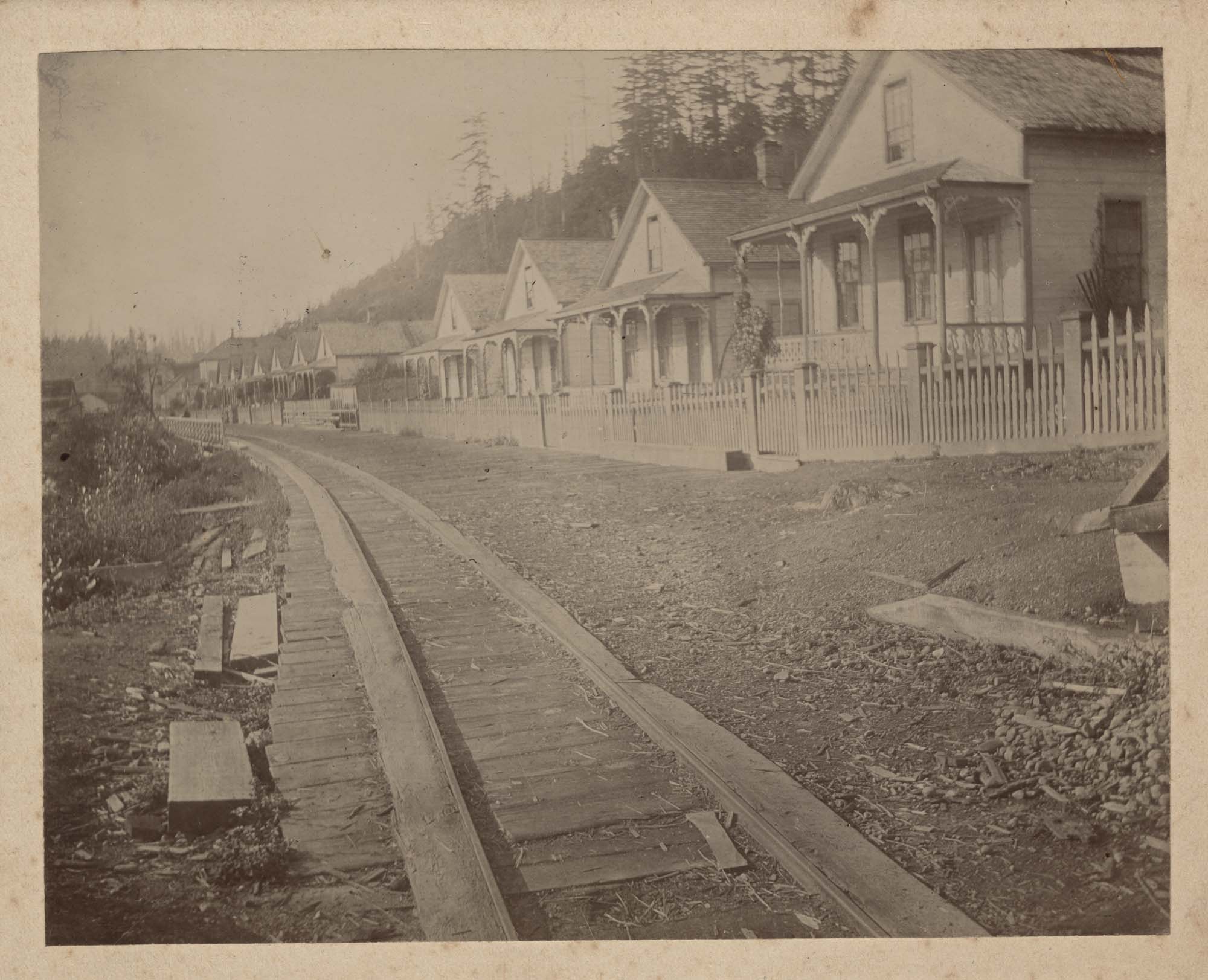 Image of Row of mill company houses in Port Blakely showing wooden tracks along road, circa 1900