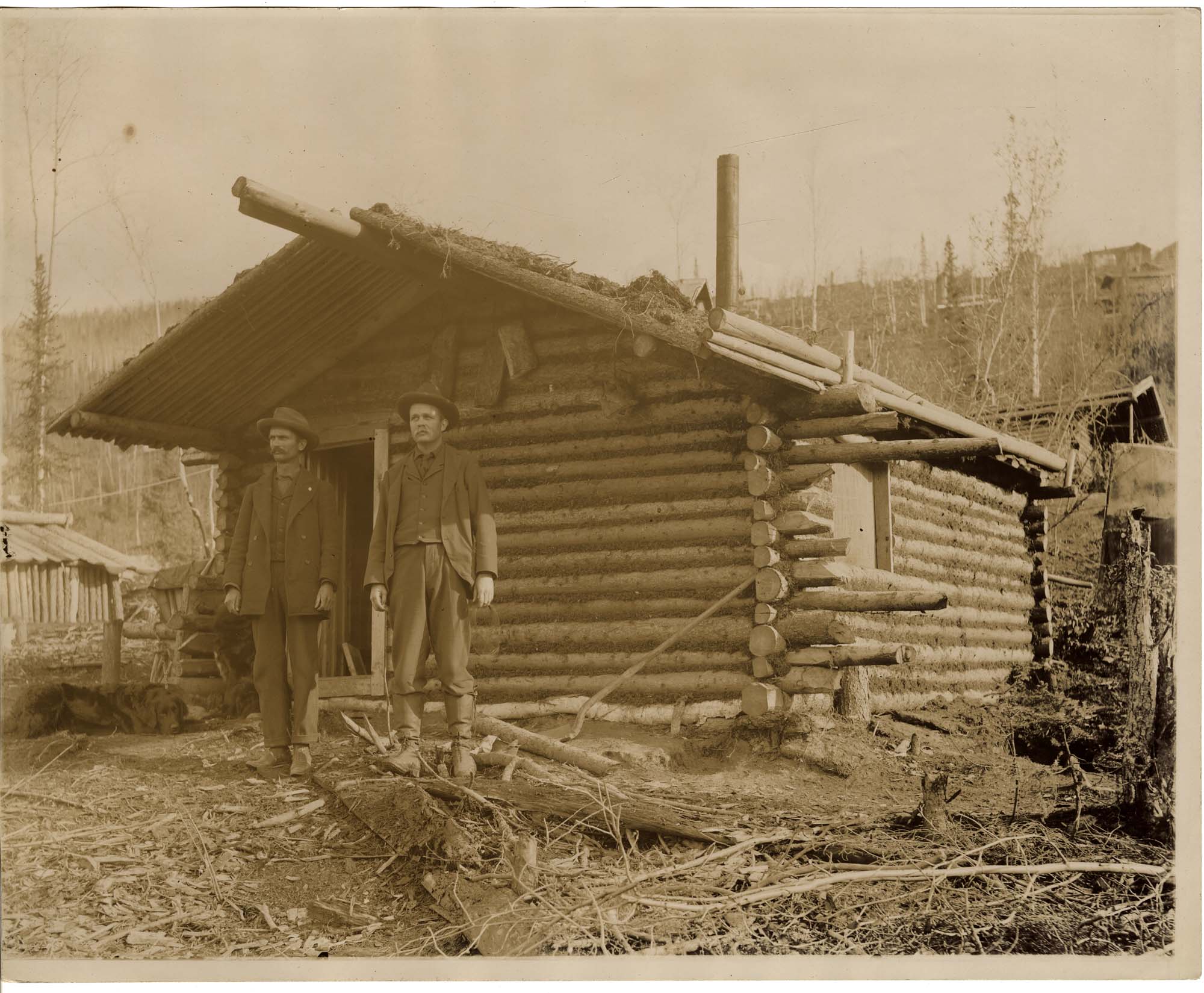 Image of Two men in front of a log cabin in the Klondike, circa 1898
