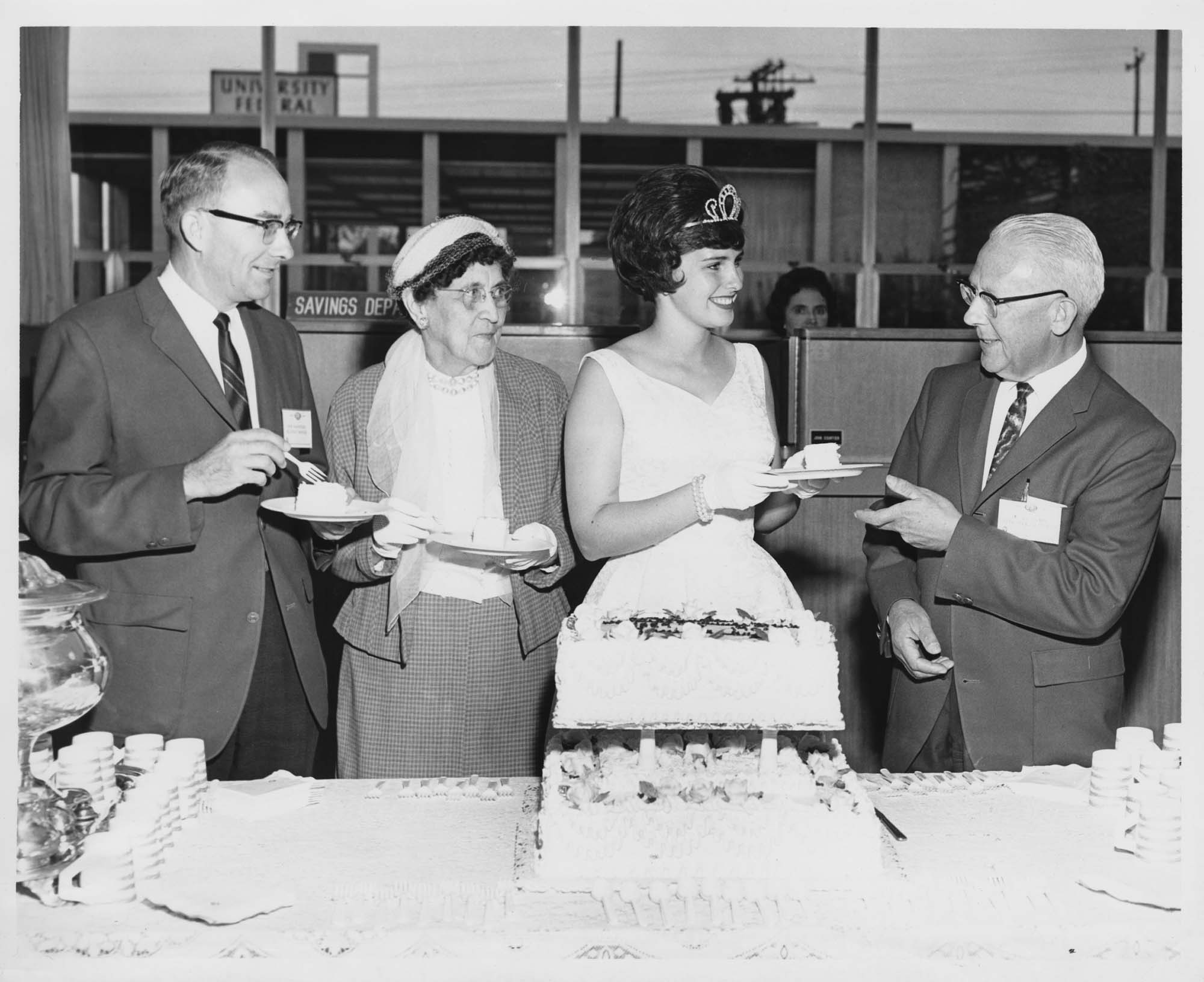 Image of Seafair Princess Barbara Foy serving birthday cake at Washington Mutual's 75th anniversary celebration, September 21, 1964