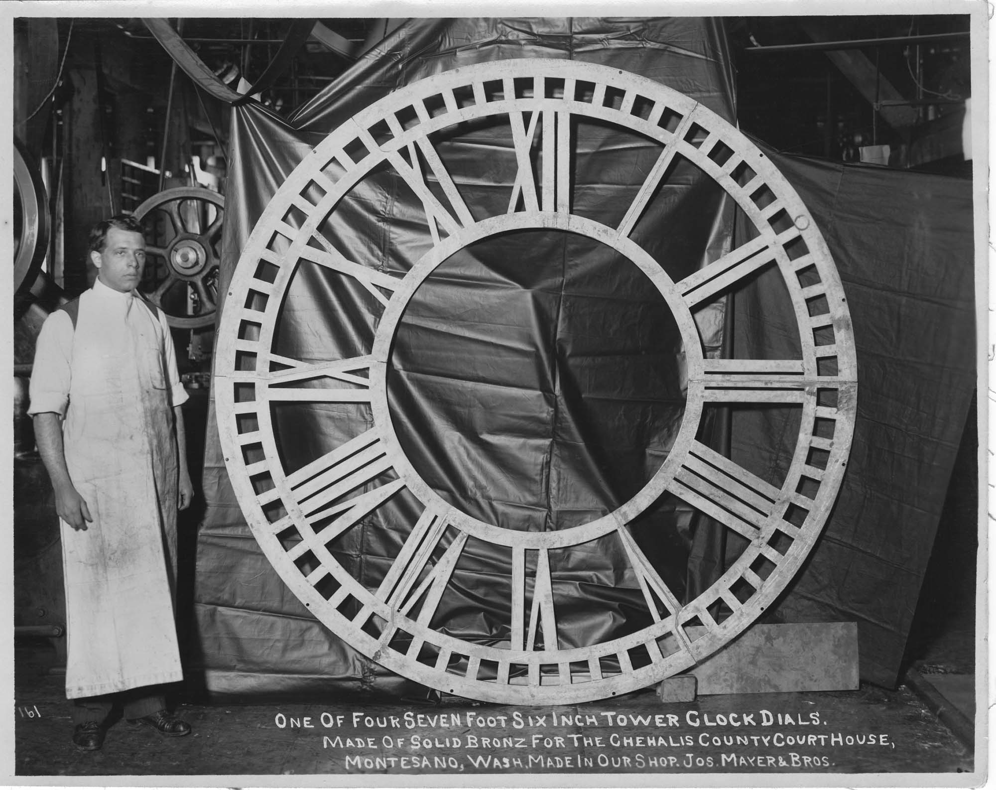 Image of Joseph Mayer & Bros. worker with clock dial for Chehalis County Courthouse, circa 1910