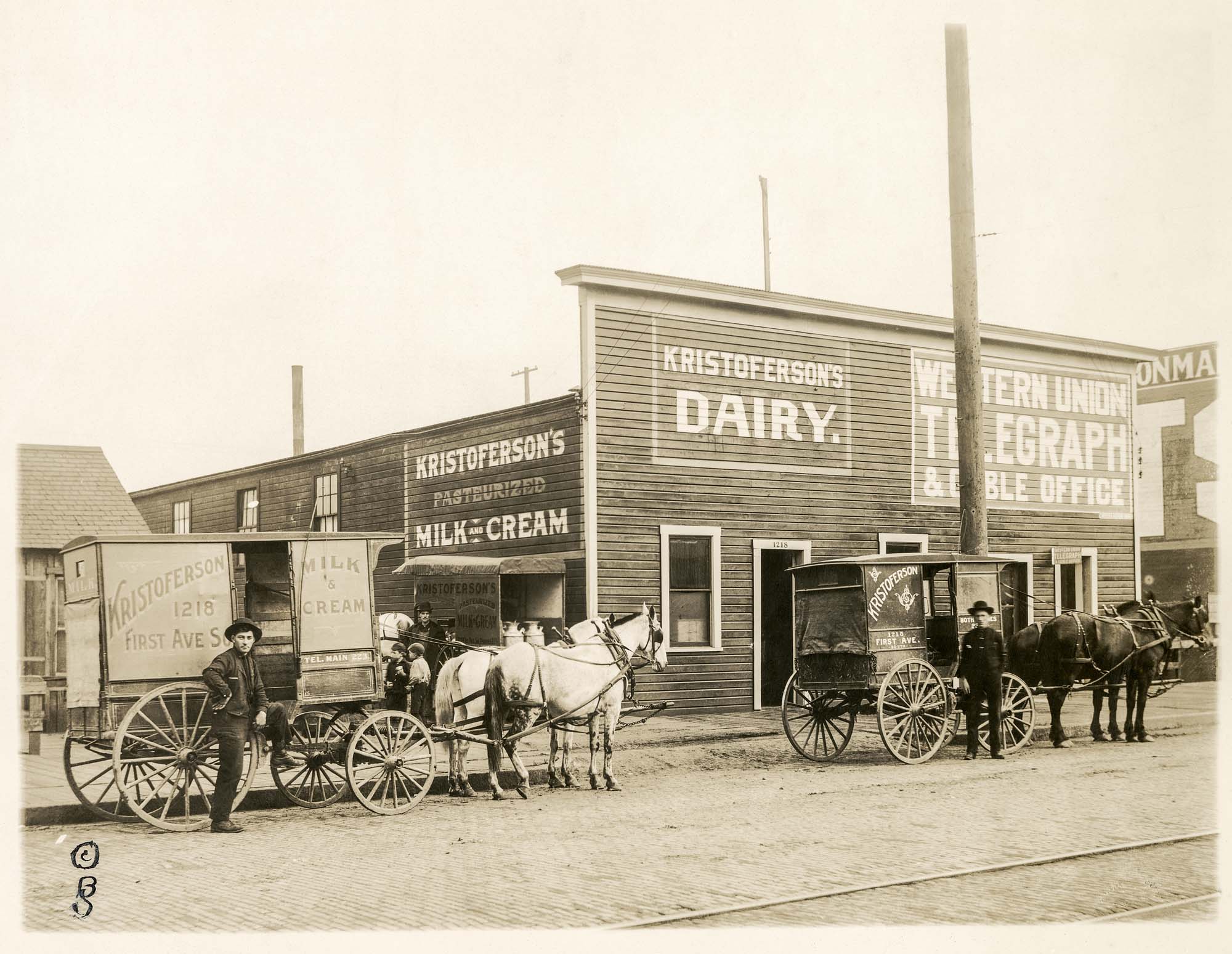 Image of Two men with horse drawn delivery wagons outside of Kristoferson's Dairy, Seattle, circa 1914