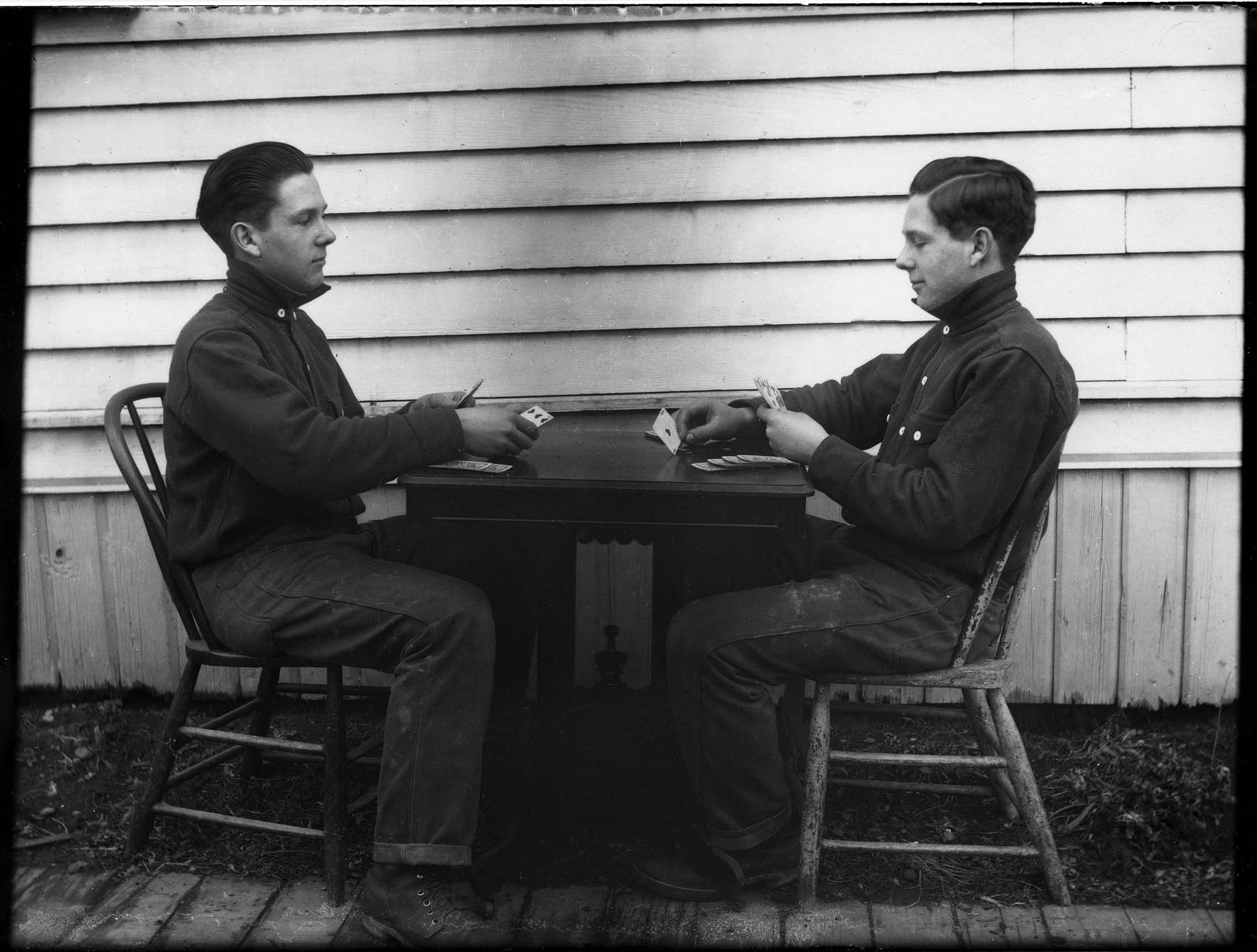 Image of Carl Henry Moen playing cards with himself in a double exposure, Seattle, circa 1910