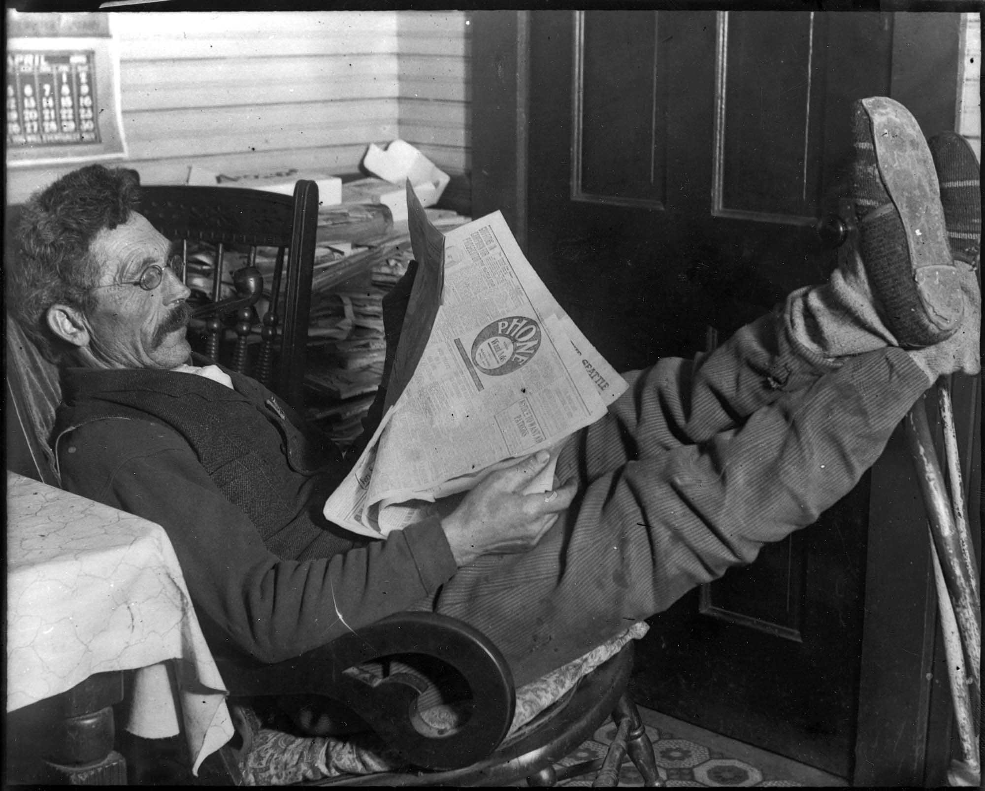 Image of Ole Moen reading the newspaper, Seattle, April 1910