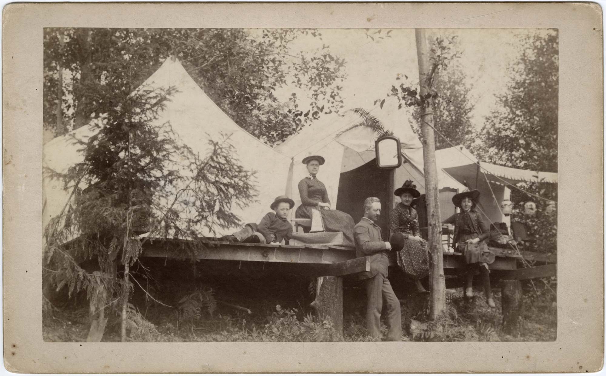 Image of Campbell and Corliss families near tents at Chautauqua, 1890